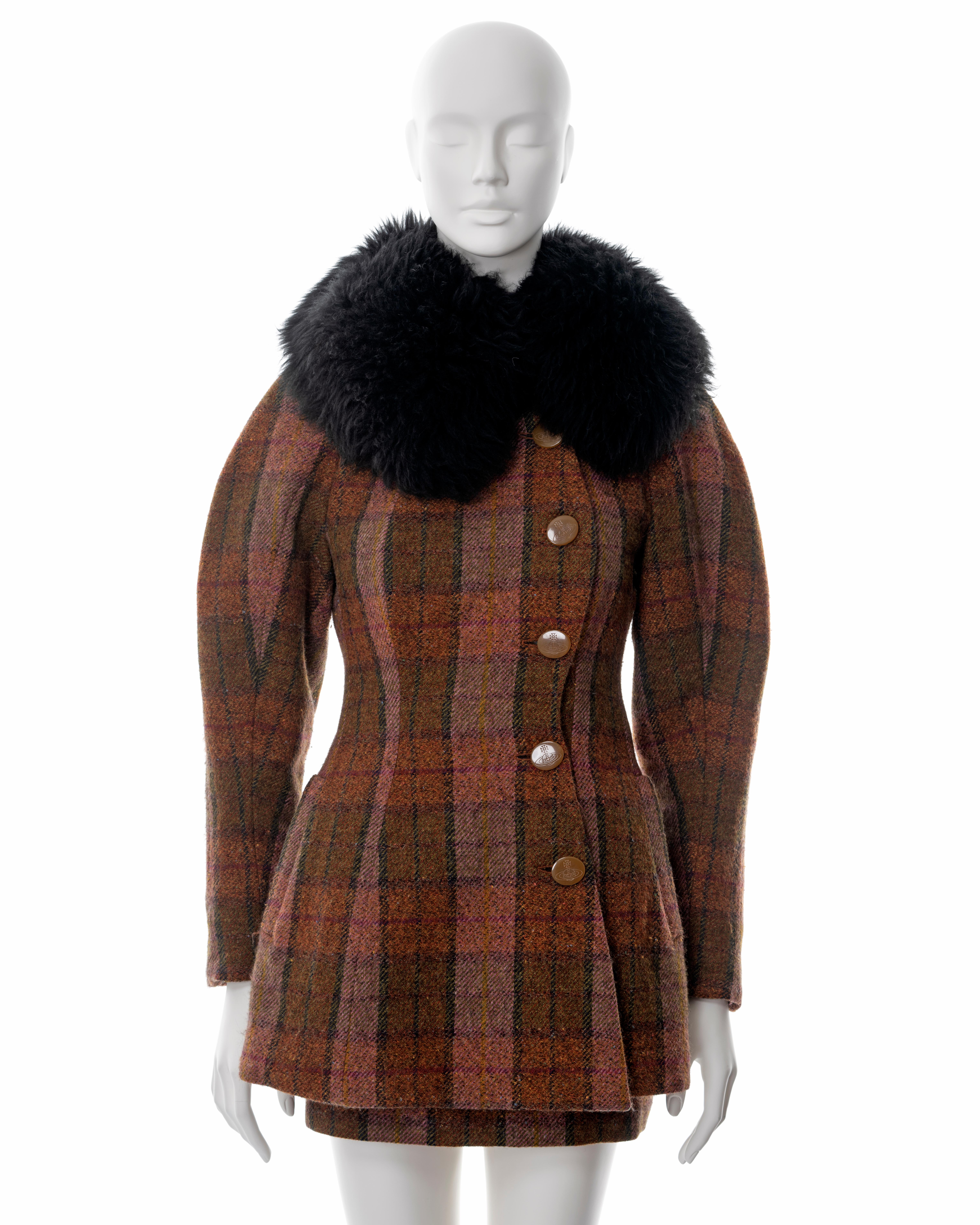 ▪ Vivienne Westwood brown tartan tweed skirt suit
▪ Sold by One of a Kind Archive
▪ Fall-Winter 1995
▪ Hourglass cut jacket with detachable sheepskin collar 
▪ Large orb-etched buttons 
▪ Leg-of-mutton sleeves
▪ Wool and Alpaca blend 
▪ Jacket rear