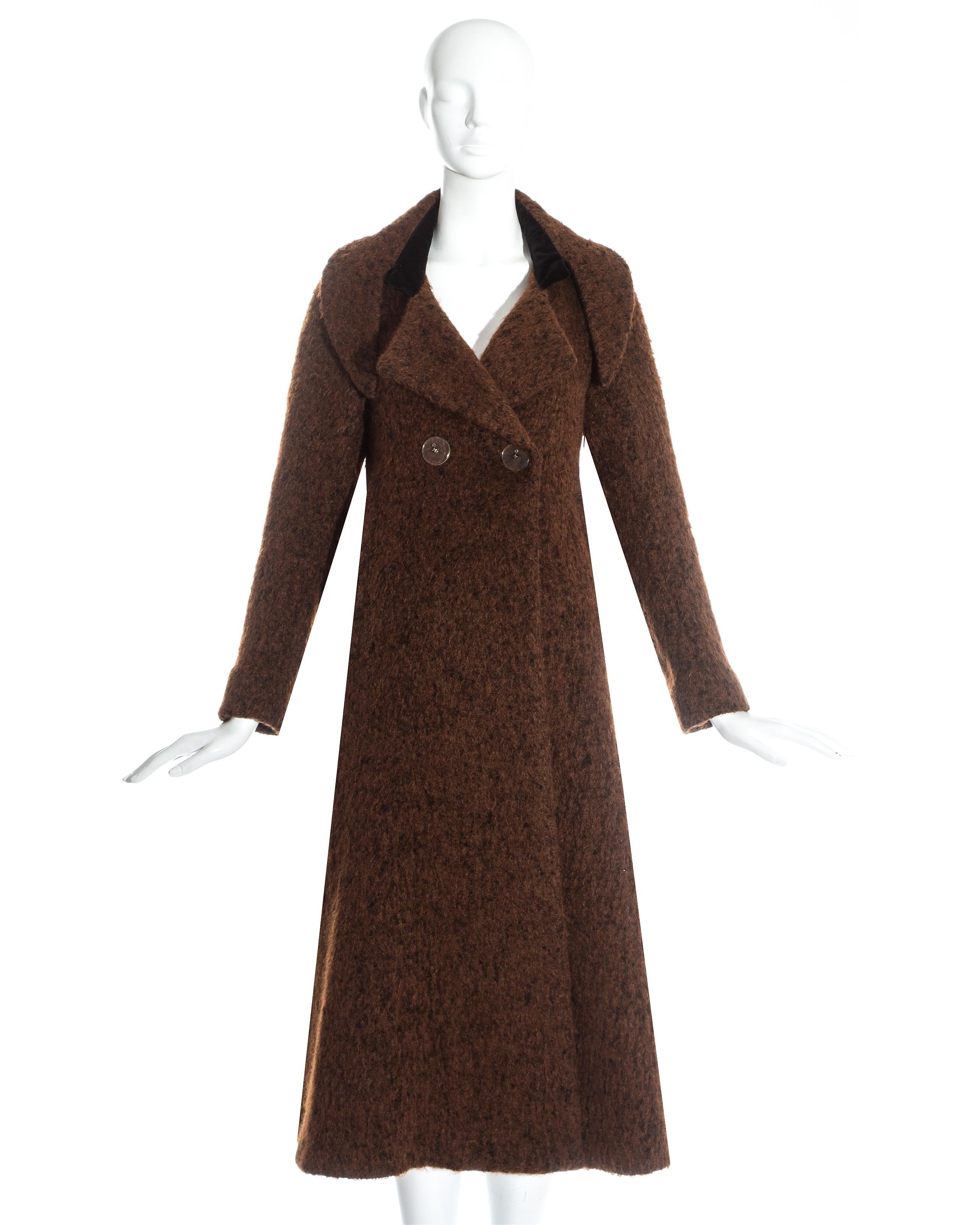 Manteau swing en laine marron Vivienne Westwood avec velours. Revers inversés surdimensionnés, grand bouton Orb en plexiglas et panneau arrière volumineux. 

Portrait, automne-hiver 1990 