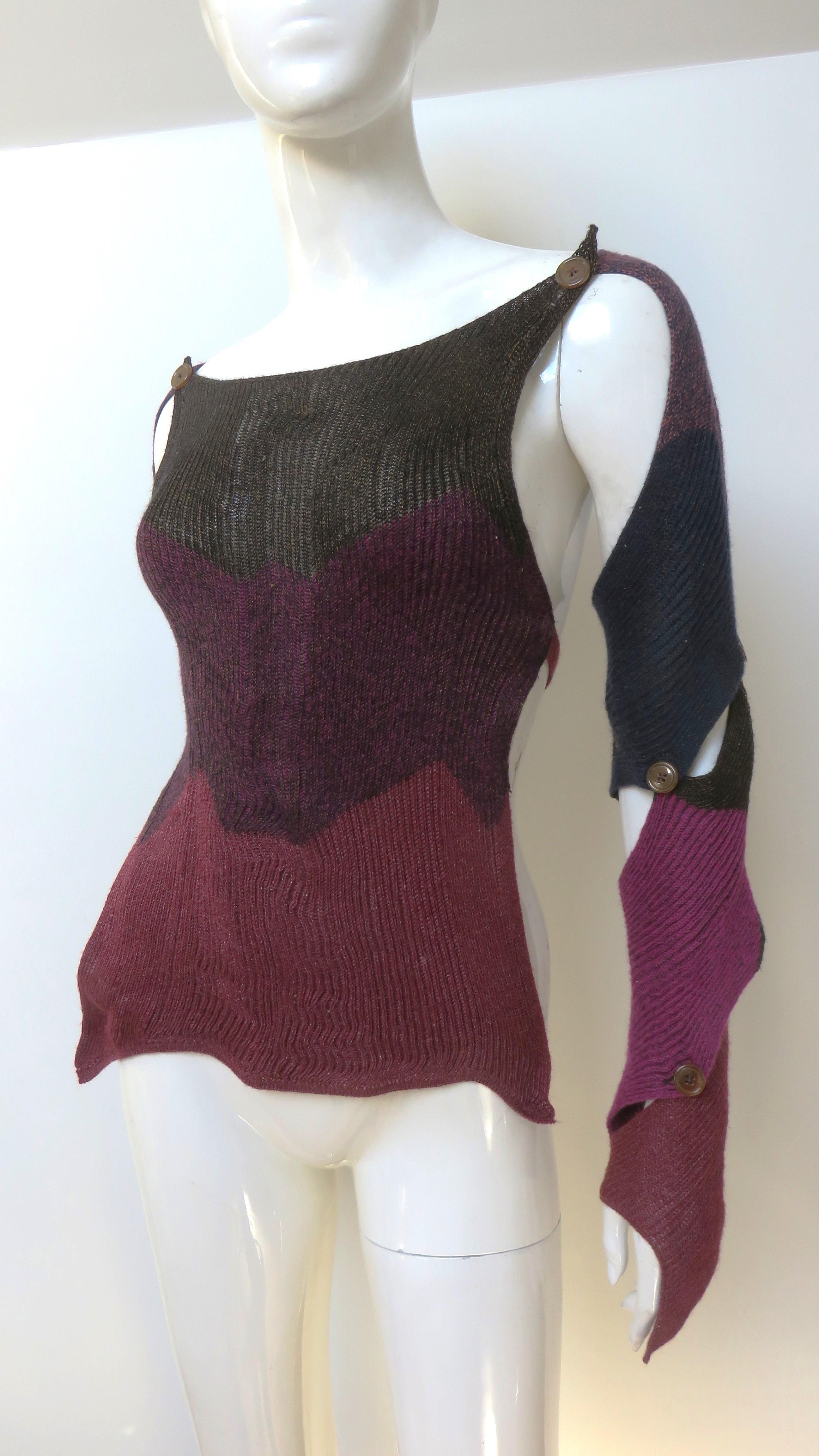 Il s'agit d'un fabuleux pull-over ou gilet en laine, unique en son genre, composé de bandes horizontales de couleur bleue, bordeaux et marron, rehaussées d'un fil subtilement brillant, signé Vivienne Westwood.  Elle est dos nu, à l'exception d'un