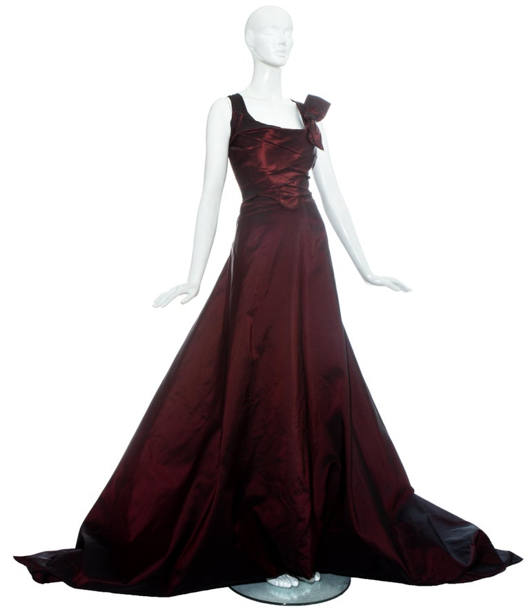Vivienne Westwood Couture red silk taffeta ballgown ensemble. Corset with decorative bow and internal boning designed to cinch the waist and push the breasts up. Voluminous skirt with train and wrap bow fastening at the back. 

Fall-Winter 1996