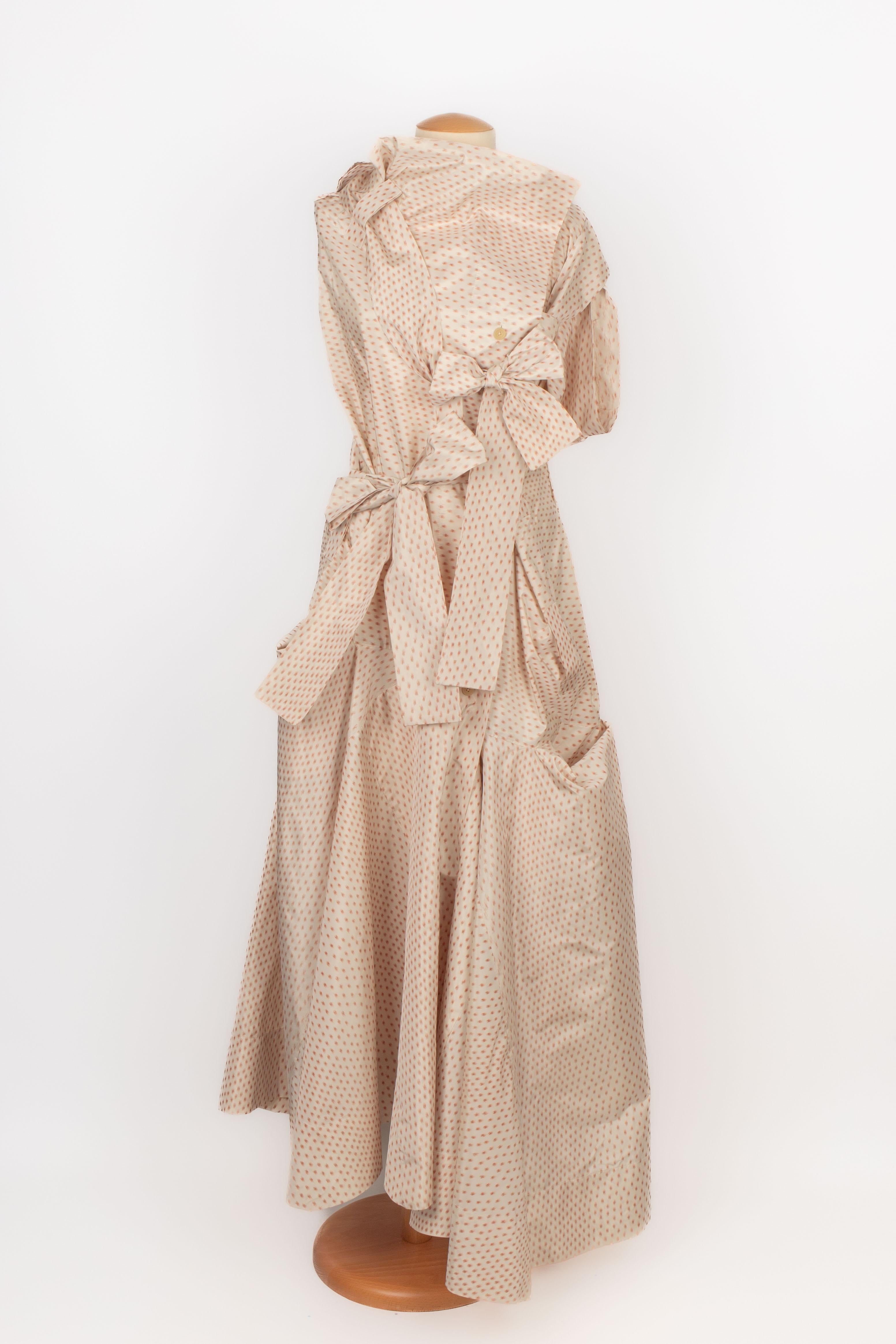 VIVIENNE WESTWOOD - (Made in Italy) Off-white taffeta dress printed with a flecked brown pattern. Belt with the same pattern. Size 16UK indicated, it fits a 42/44FR.

Condition:
Very good condition

Dimensions:
Length: 133 cm

SKU:VR139