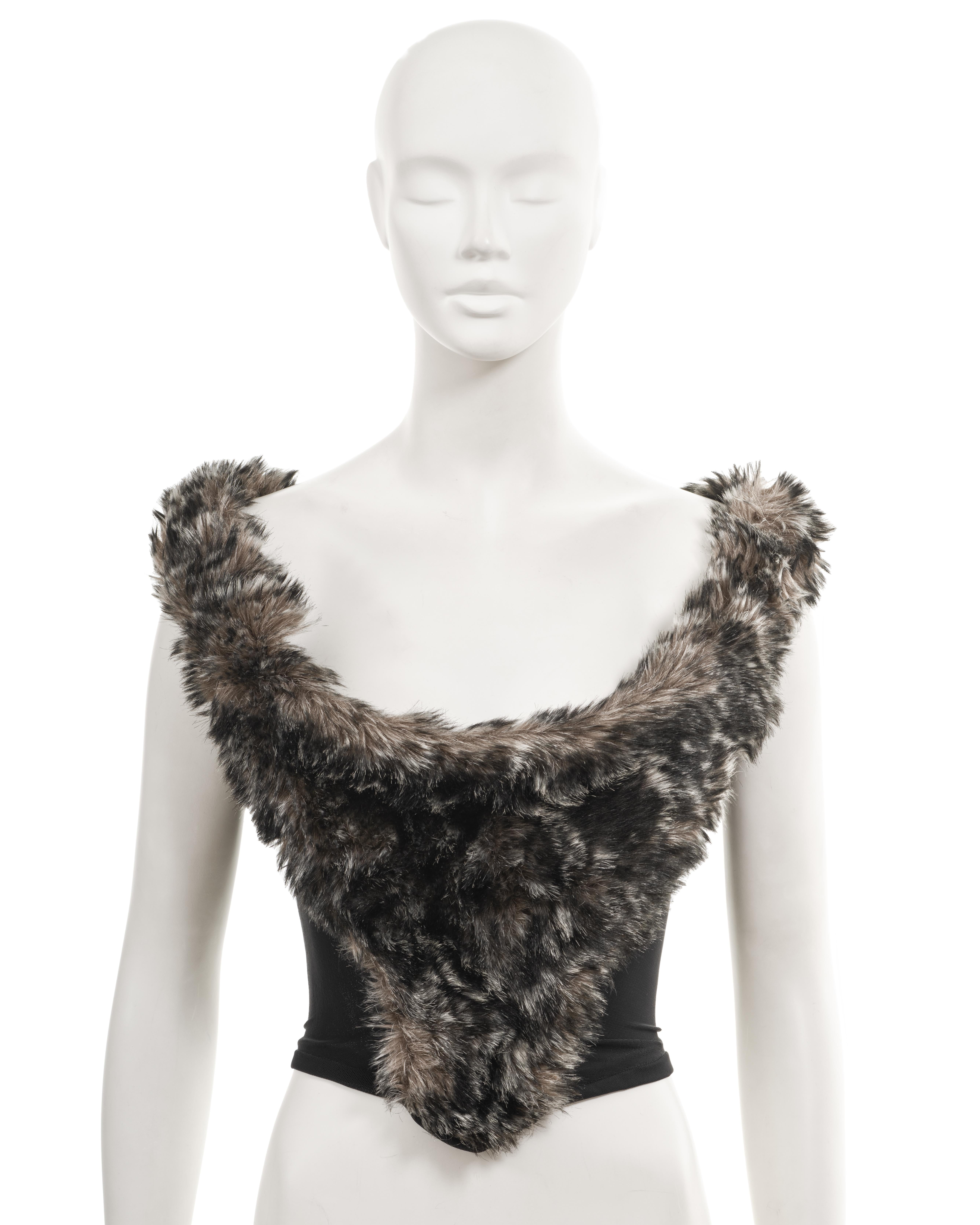 ▪ Archival Vivienne Westwood Corset
▪ Fall-Winter 1993
▪ Sold by One of a Kind Archive
▪ Stomacher and shoulder straps adorned with faux fur 
▪ Black power-mesh corset bodice 
▪ Internal boning provides excellent support and structure, allowing the