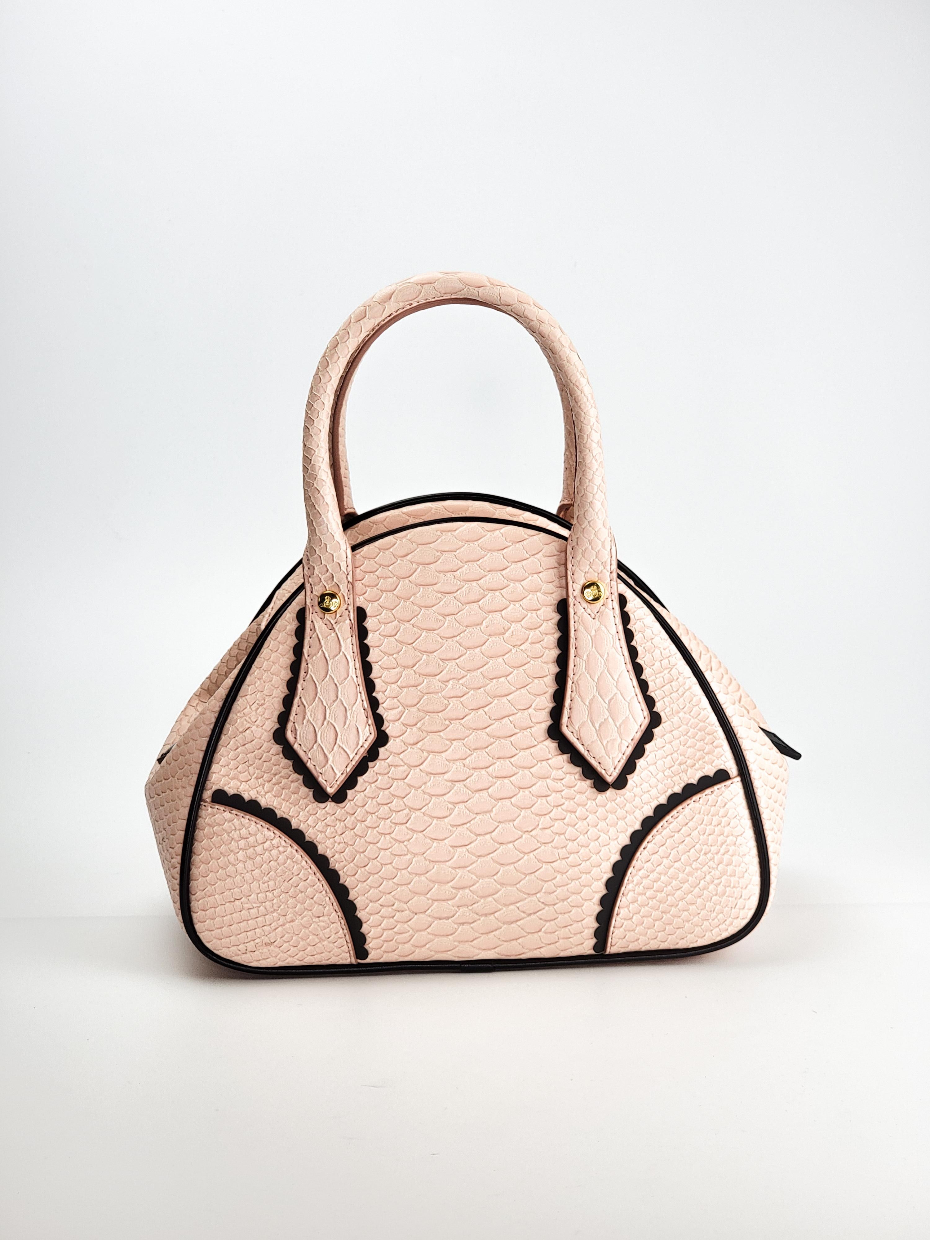 This Vivienne Westwood's Frilly Snake Yasmine bag is perfect for summer. This pink Frilly snake handbag features a glossy snake skin finish and the iconic Orb in gold tone on the front with black frilly fringing and piping. The bag opens with a top