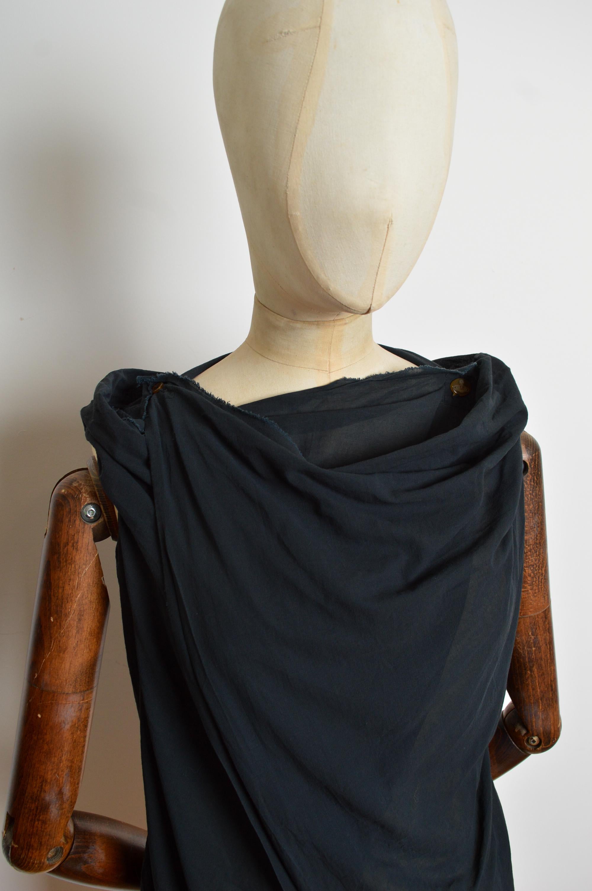 Camicetta Vivienne Westwood Gold Label realizzata in garza di cotone leggera con orli grezzi, bottone con orbita e linea del collo drappeggiata che si incrocia sul davanti. 
Taglia; consigliato UK 6-8
Le misure sono indicate in pollici ('')
Da fossa