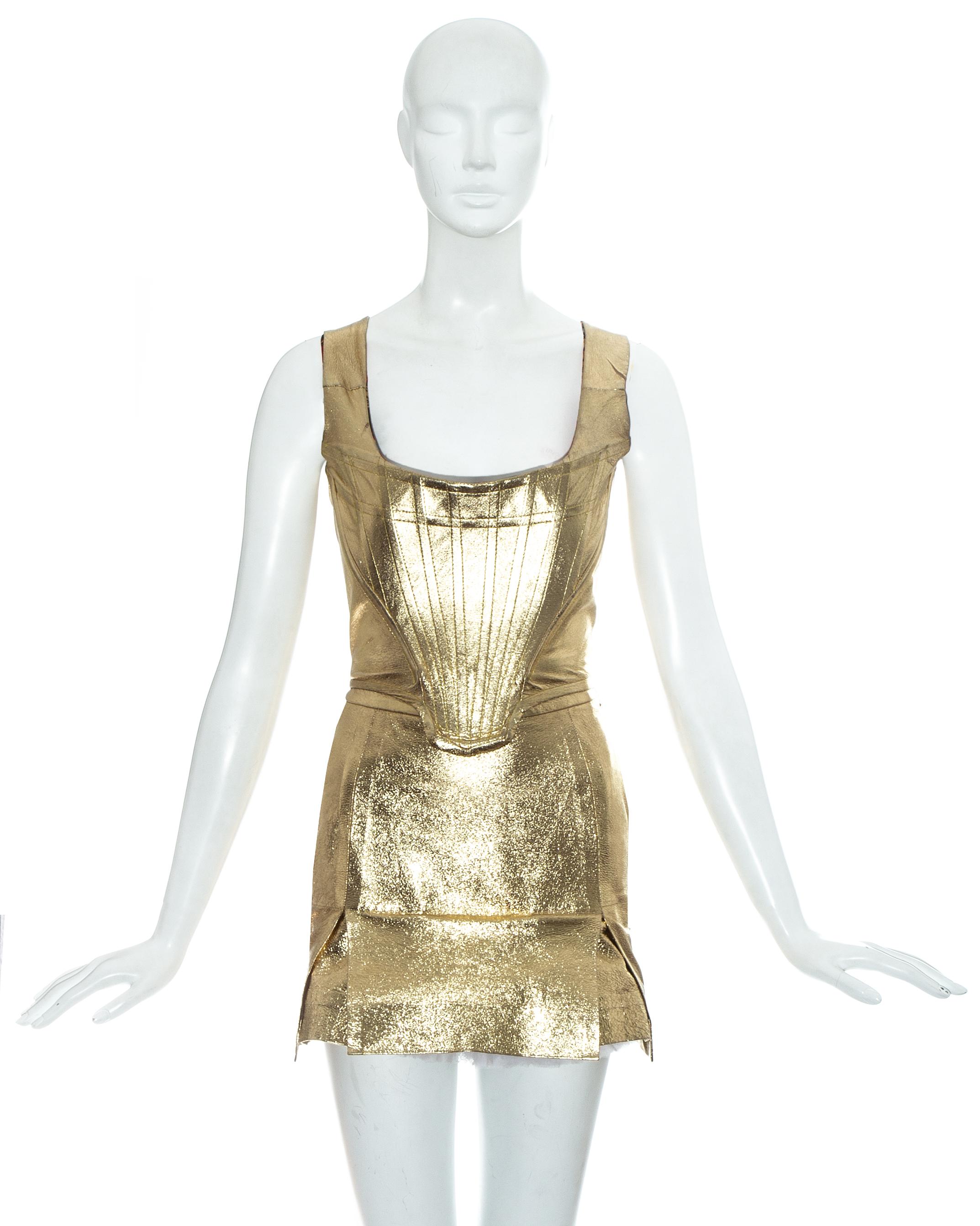 Vivienne Westwood; gold leather corset and skirt ensemble. Corset with internal boning, designed to cinch the waist and push the breasts up. High waisted mini skirt designed backwards with vent at the front and tulle petticoat.   

Time Machine'