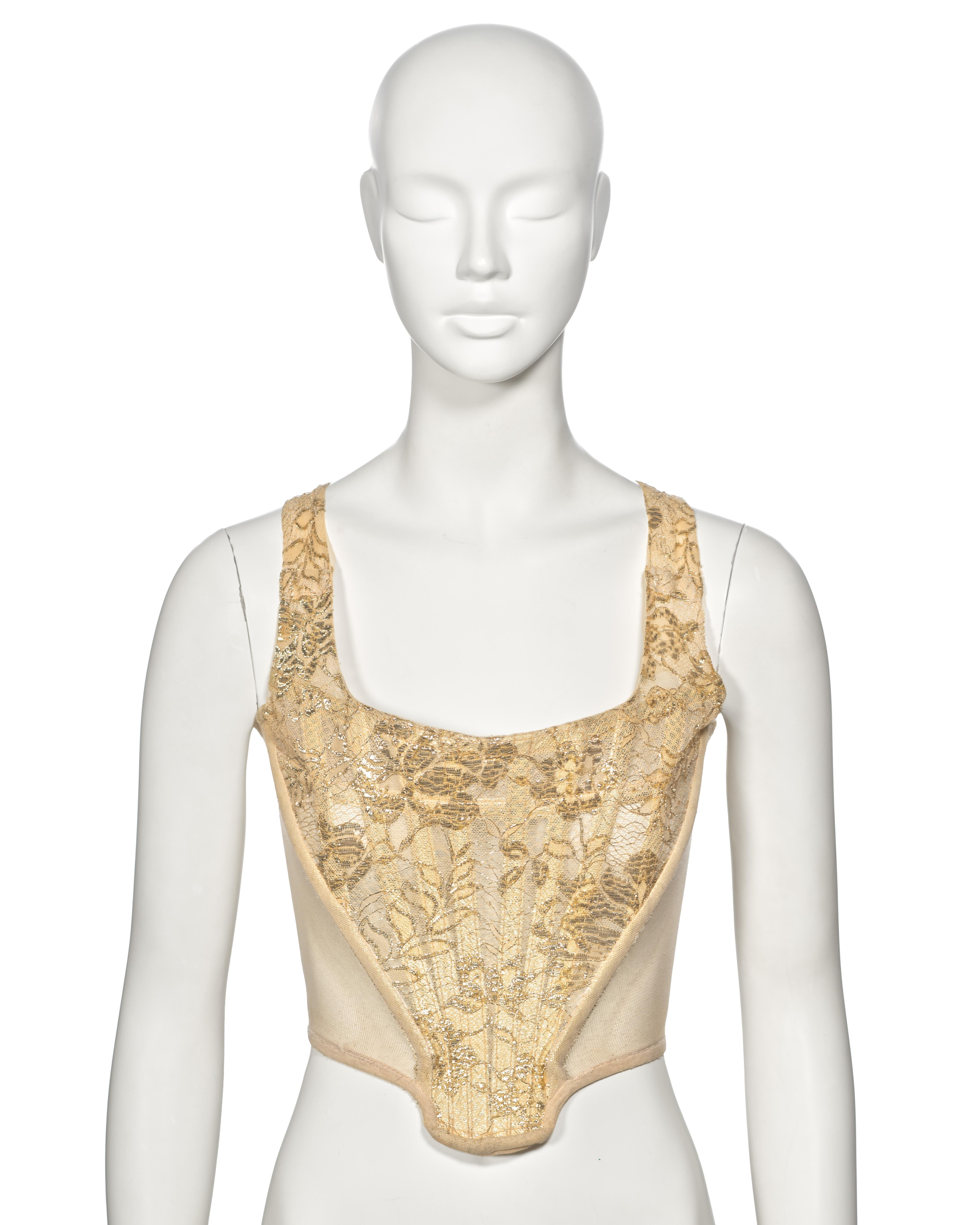 ▪ Archival Vivienne Westwood Corset
▪ Fall-Winter 1993
▪ Sold by One of a Kind Archive
▪ Gold metallic lace 
▪ Ivory cotton mesh side panels 
▪ Built-in boning 
▪ Zip closure at the centre-back  
▪ Size: UK10 - US6 - FR38
▪ Made in England

The