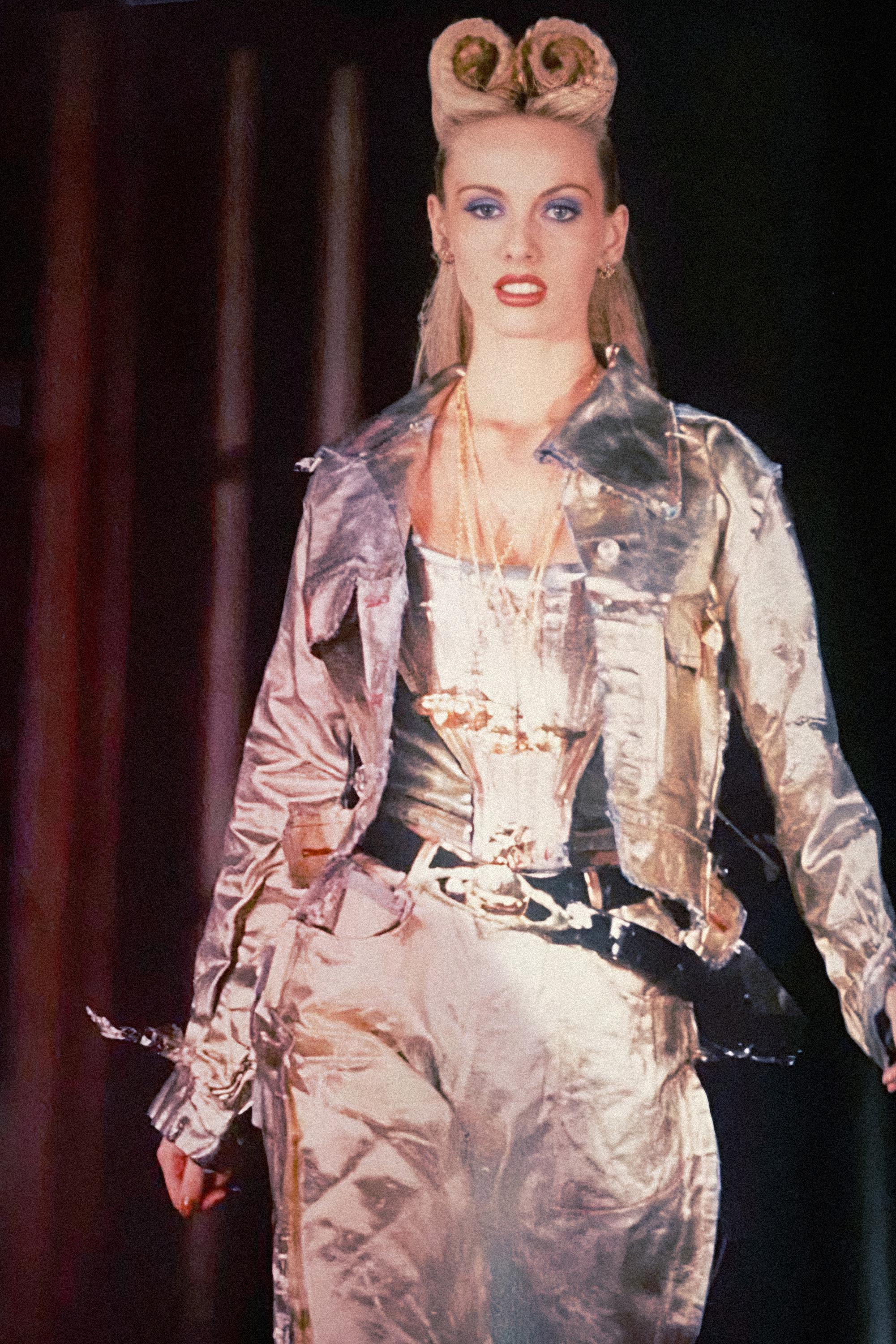 This Vivienne Westwood gold-painted denim jacket is from the Spring-Summer 1993 ‘Grand Hotel’ collection. Made from cotton denim, this jacket features a metallic gold coating that gives it a distinctive and eye-catching appearance. The coating is