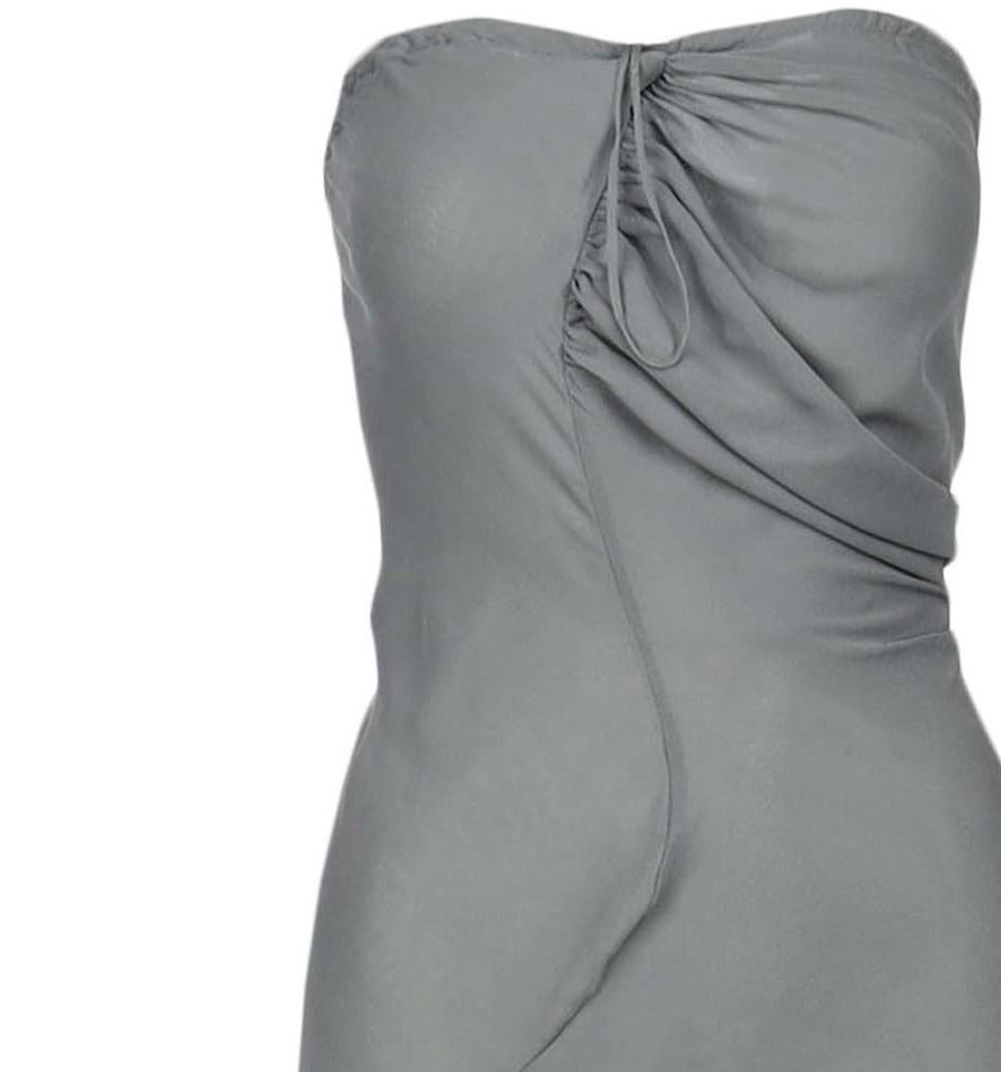 Elevate the glamour quotient with this Vivienne Westwood Grey Column Gown which showcases a middle slit and a knot around the stitch column. The strapless dress can be tightened with the zipper on the back and pairing it with heels can further