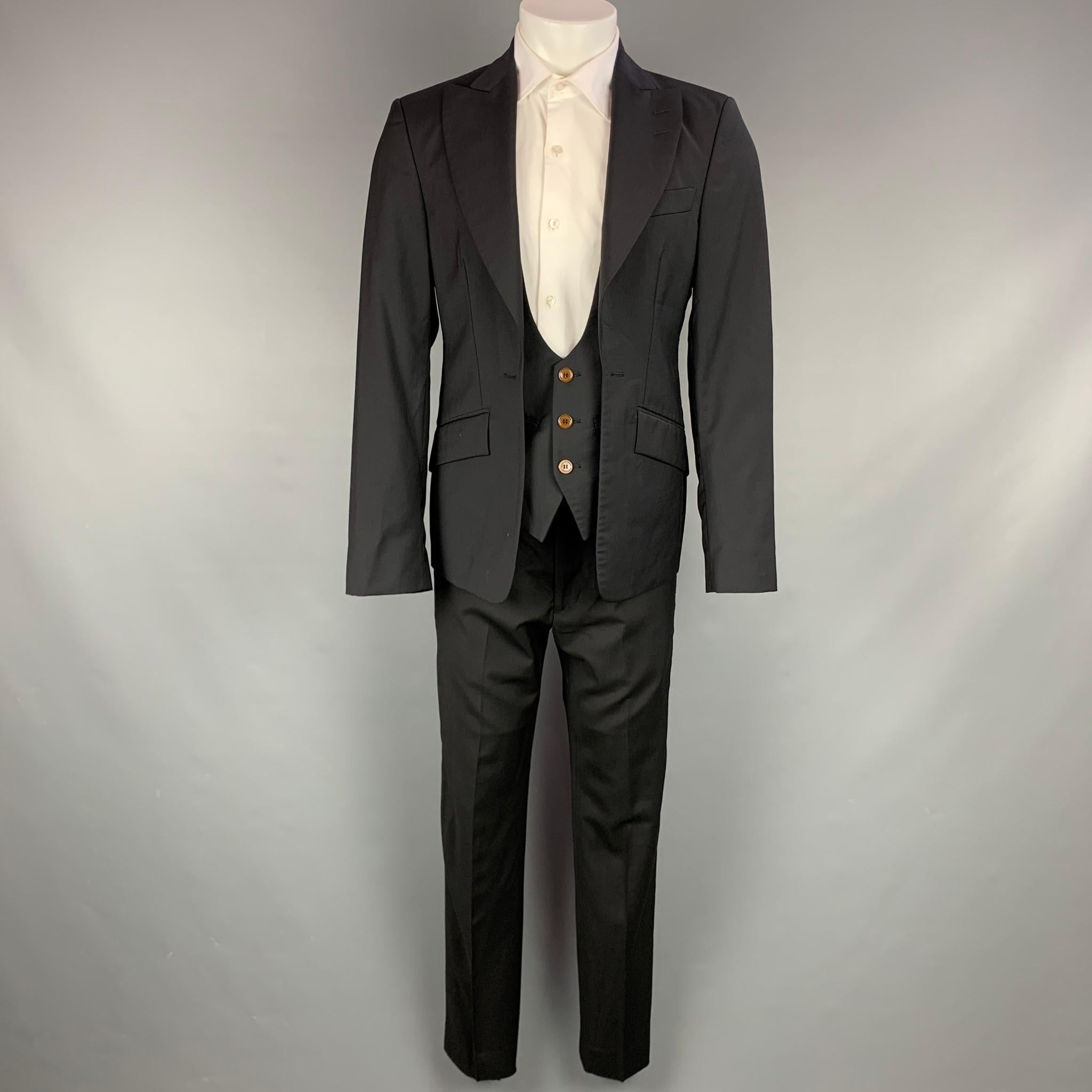 VIVIENNE WESTWOOD MAN suit comes in charcoal grey wool with a full liner and includes a single breasted, simulated vest, buttoned sport coat with peak lapel and matching flat front trousers. Made in Italy.

Very Good Pre-Owned Condition.
Marked: