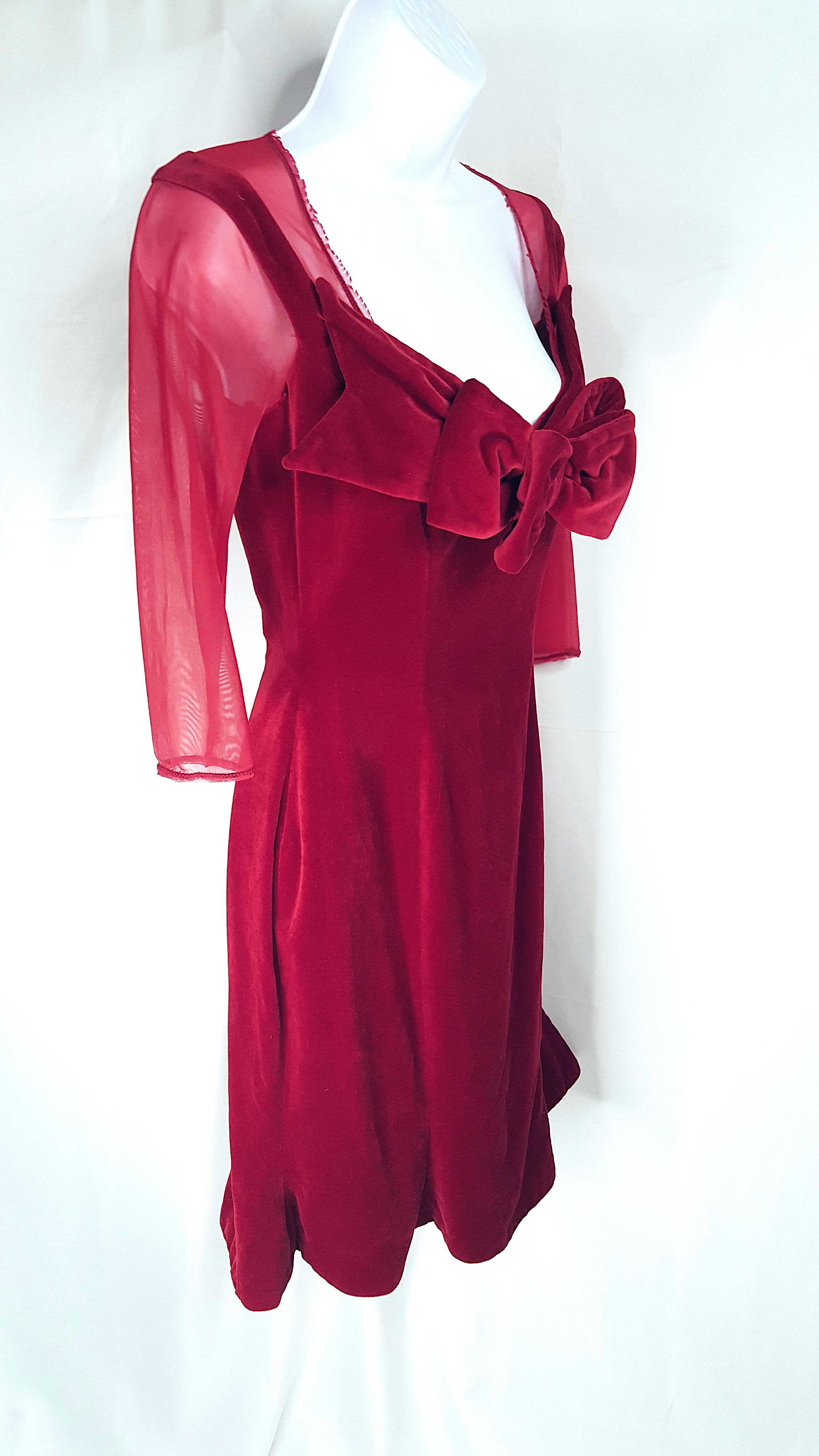 British Vivienne Westwood (1941-2022) designed this corset-style hourglass red velvet evening dress with its outsized bow and sheer moire faux-underlay while producing her 