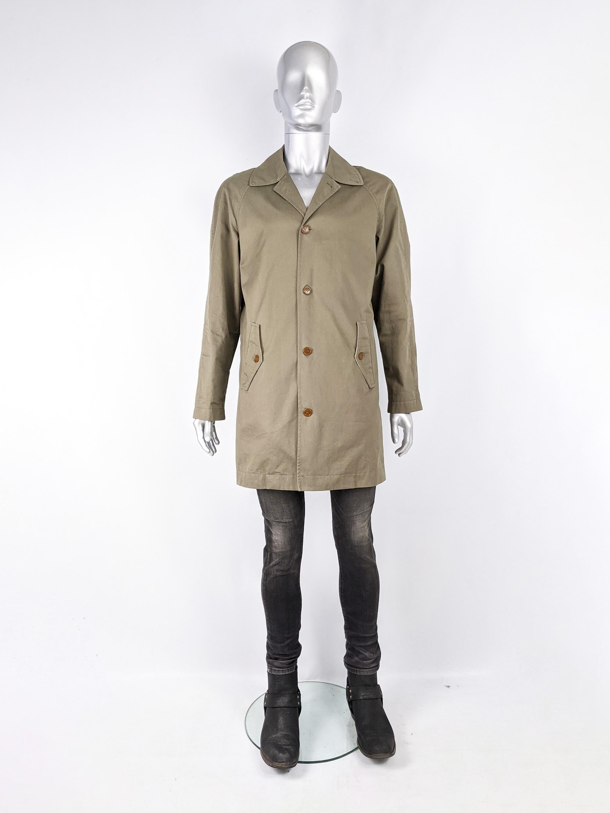 A stylish and rare mens Vivienne Westwood Man coat in a khaki cotton gabardine with a wide spread collar, Westwood's signature amber coloured buttons and a luxurious touch with the polka dot and logo patterned cotton facing on the fabric and on the