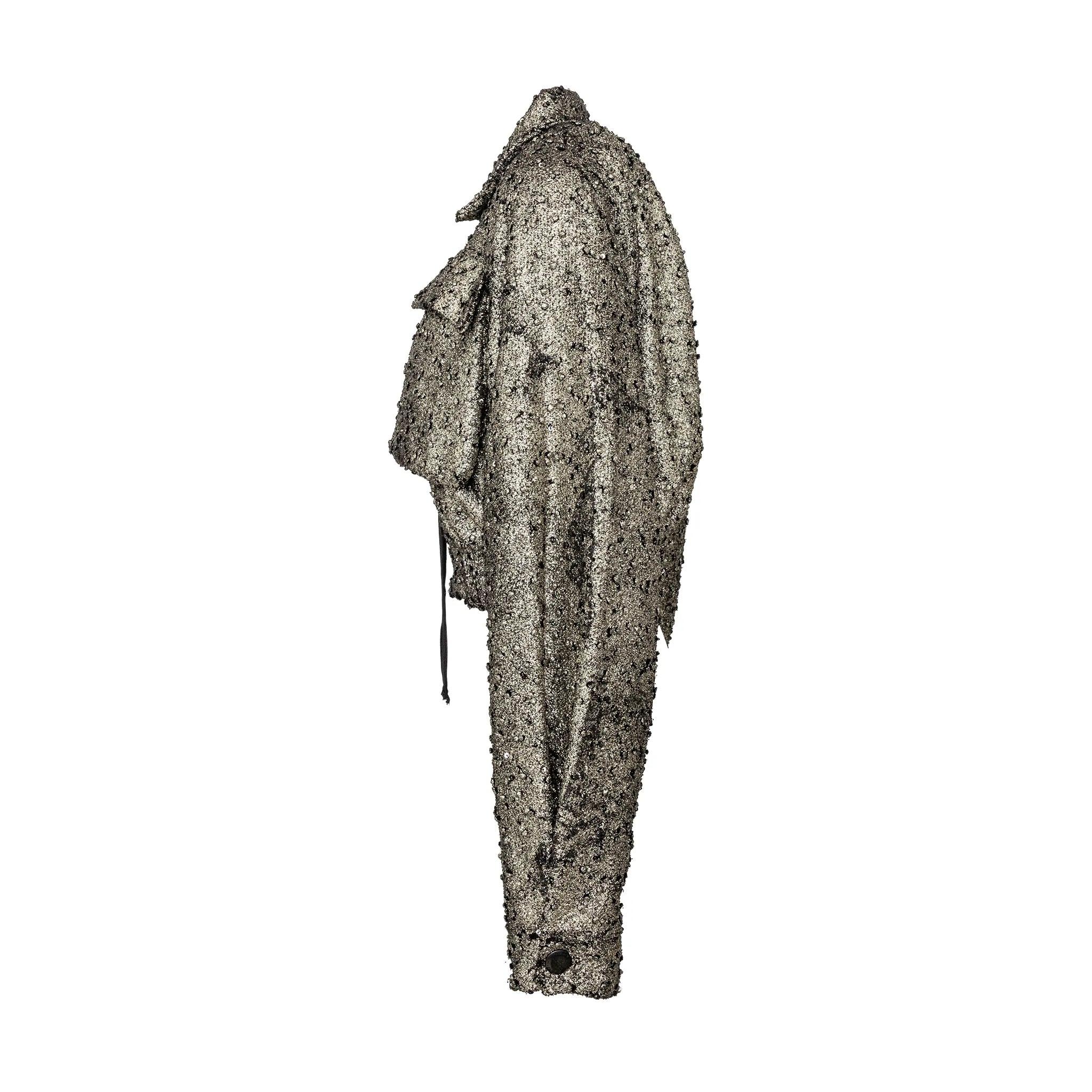 Jacke im Bomberstil des Labels Vivienne Westwood Anglomania. Strukturierter Metallic-Stoff mit Vordertaschen, Reißverschluss, Kragen und elastischem Saum in der Taille.
 Bemerkungen: der Kragen ist etwas verblichen.  
 Maße: Ärmel (ab