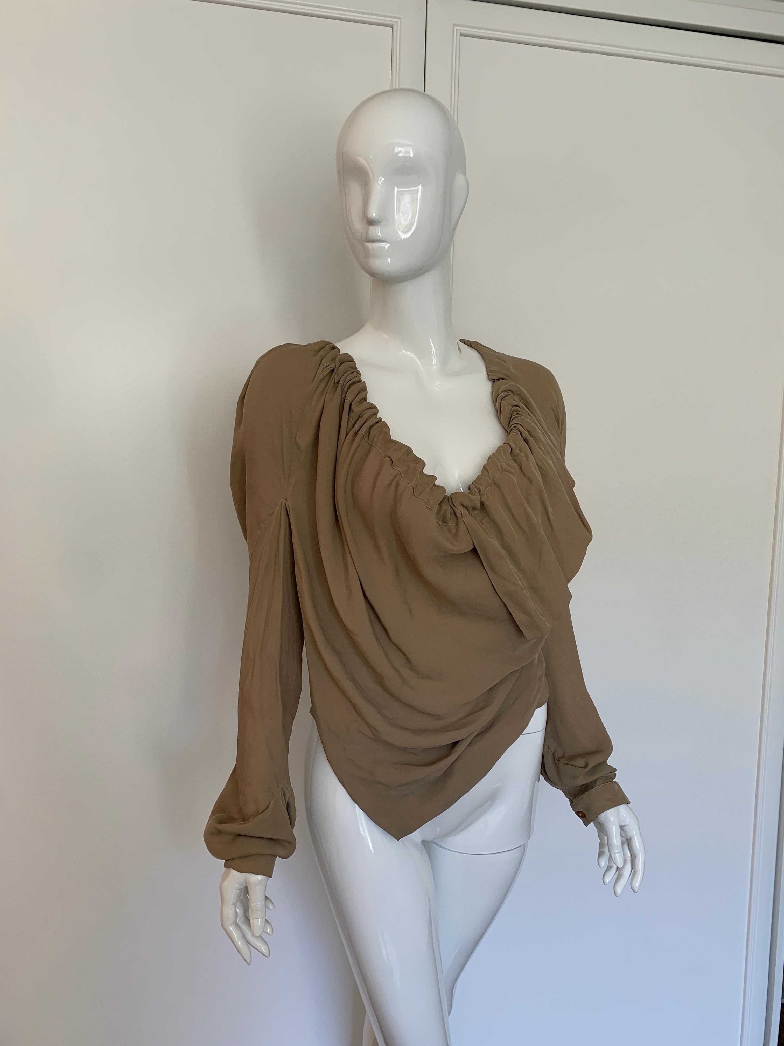 New with Tags Vivienne Westwood Peasant Blouse. Please refer to photos for different ways to wear the blouse. Can be worn in a low neck style, off the shoulder, or one shoulder. Mint condition, size M, color tan. 

Size UK 12 US 6 (size M ) 

Retail