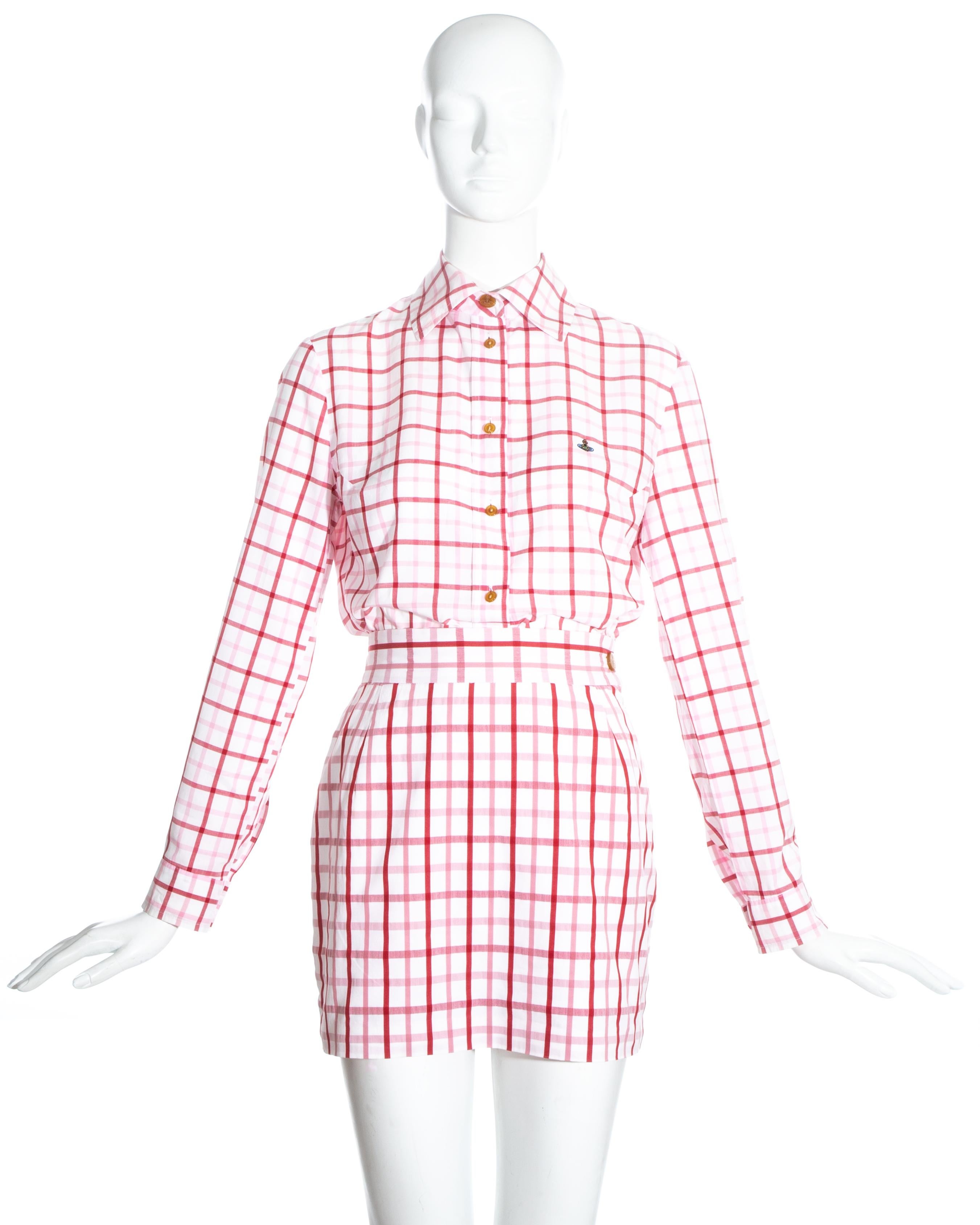 Vivienne Westwood pink and red checked cotton skirt suit comprising: button up shirt with embroidered orb, and high waisted mini skirt.

Spring-Summer 1994