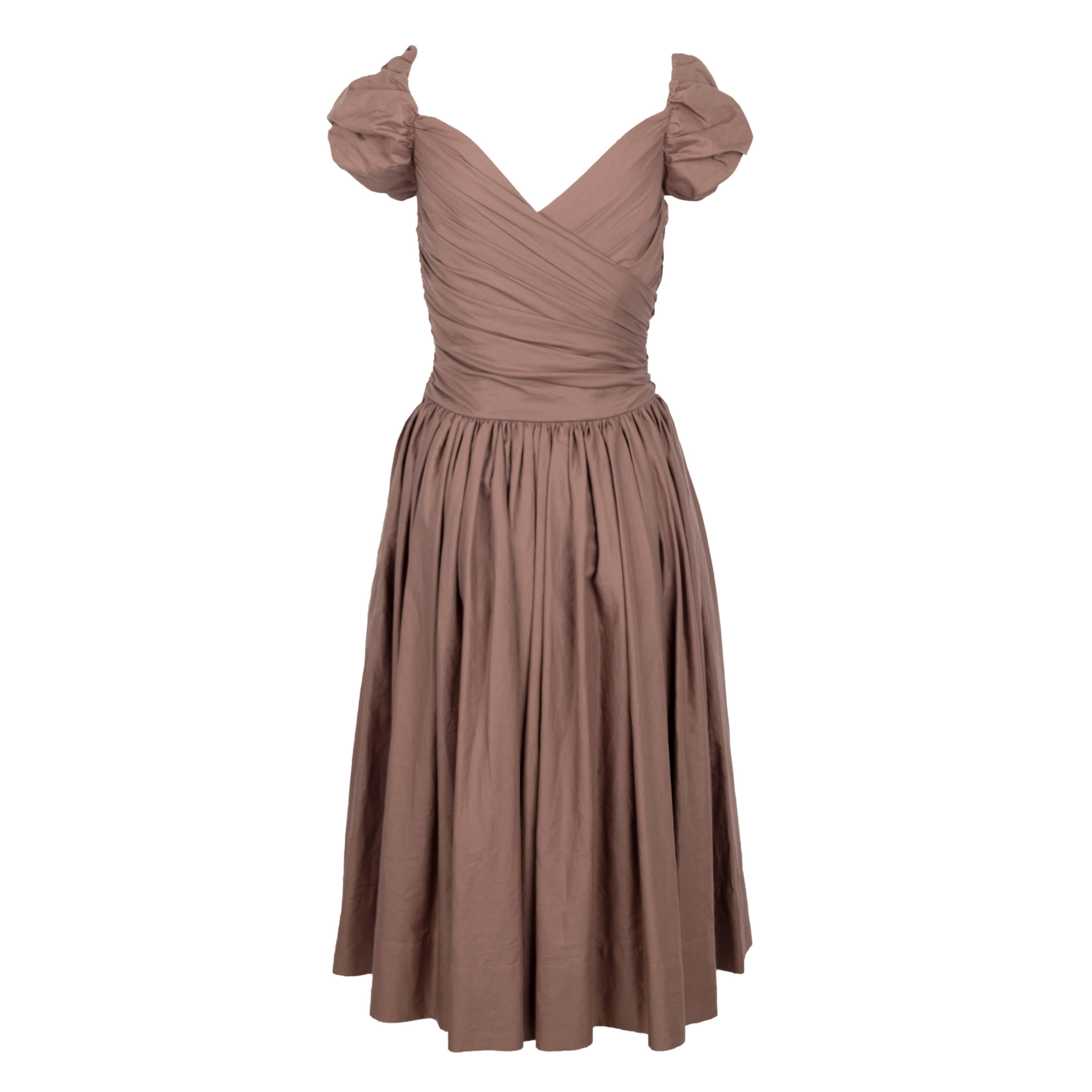Vivienne Westwood red label cotton midi dress in a mauve-brown color that features heavy gathering at the waist and ruching on the front. The sweetheart neckline and the short balloon sleeves spreads to give an off-shoulder look. The dress has a