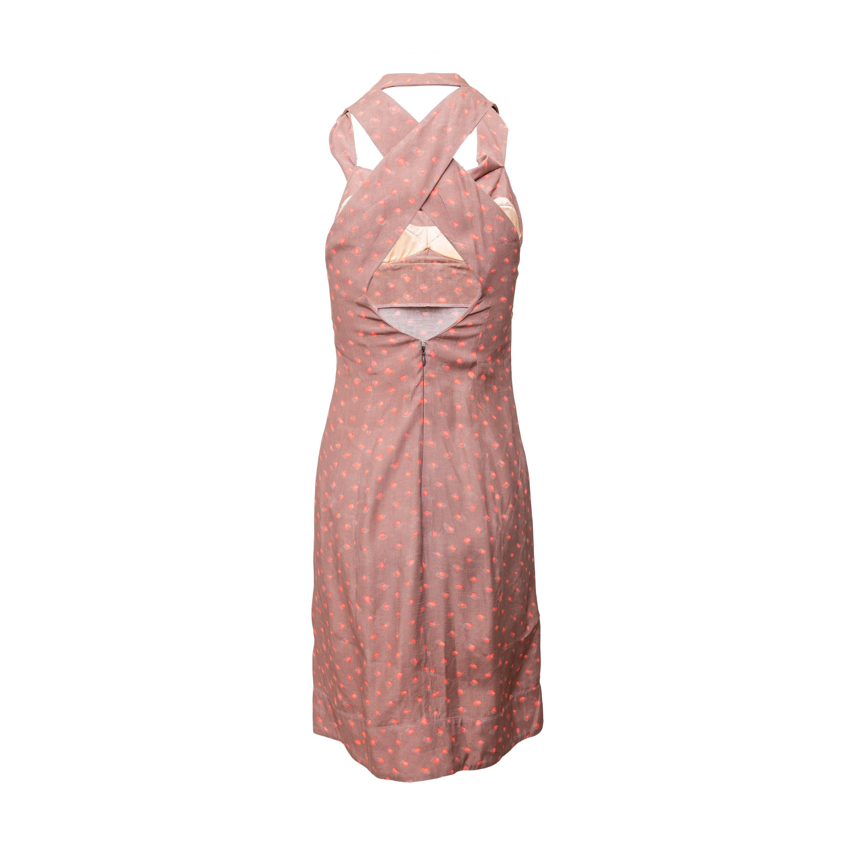 Este vestido de Vivienne Westwood está confeccionado con suave y cómodo rayón y presenta un divertido estampado de lunares en dos tonos. Perfecto para el verano, presenta un diseño de espalda cruzada y nudo de corbata en el escote con frunces. Forma