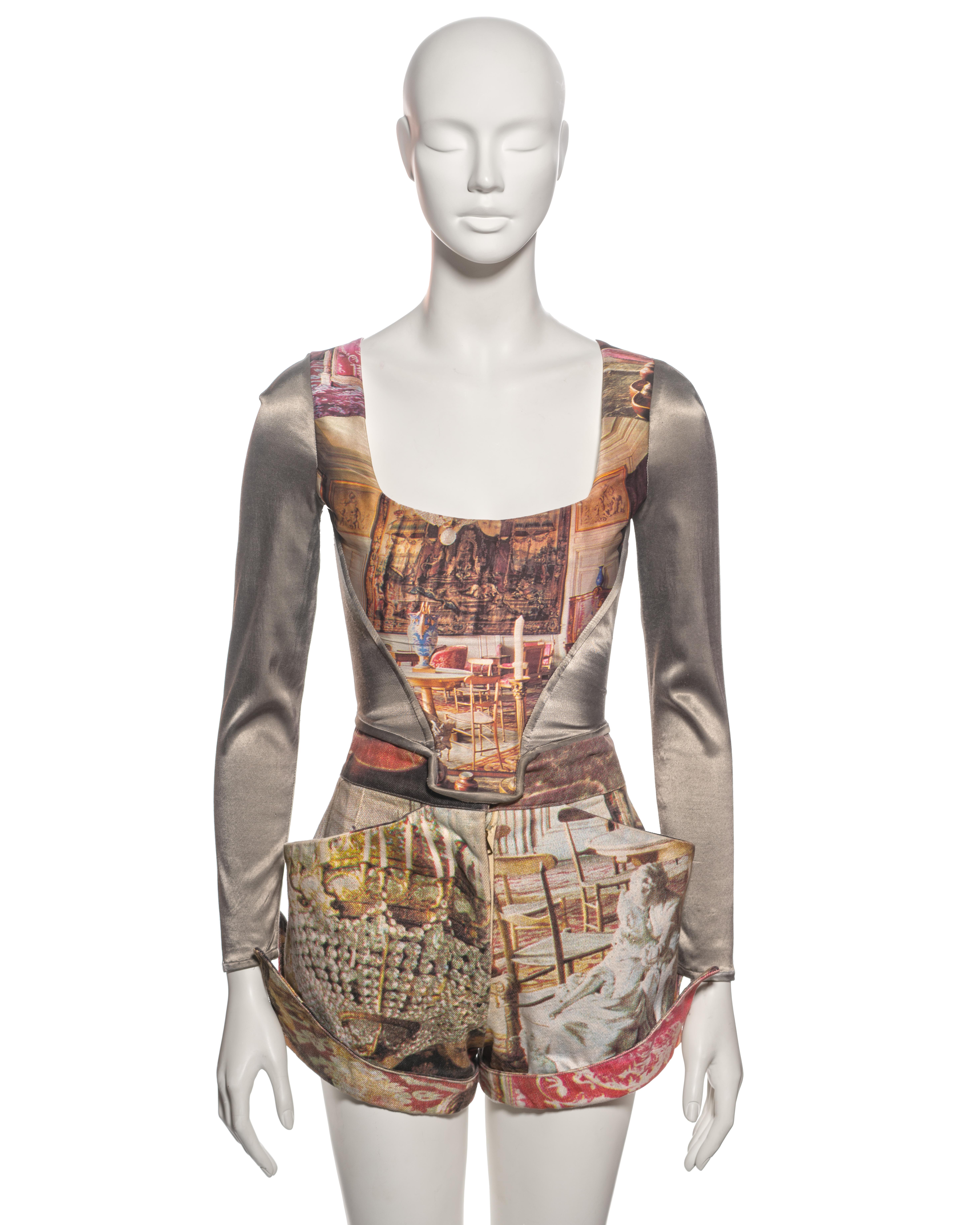 ▪ Archival Vivienne Westwood Corset and Shorts Set
▪ Spring-Summer 1992
▪ Sold by One of a Kind Archive
▪ Long sleeve corset with a photographic print to front and back, of an 18th-century salon
▪ Side panels and sleeves of silver-grey lycra
▪