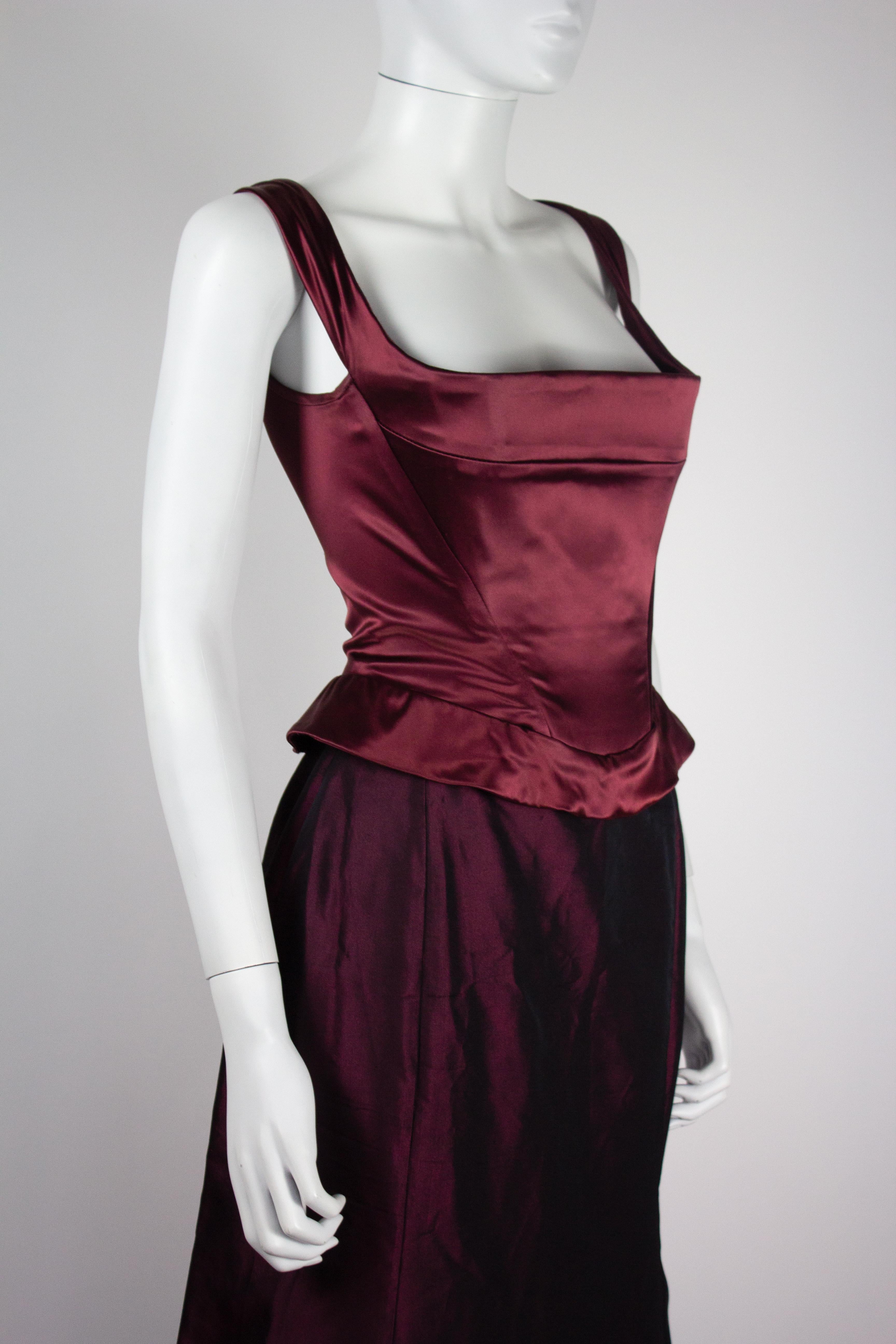 Ensemble corset et jupe de Vivienne Westwood de la collection automne-hiver 1996. La couleur est un bordeaux irisé/violet foncé en soie. 

Condit
Très bon état dans l'ensemble. Le corset n'a pas de défaut majeur, quelques ternissements au niveau de