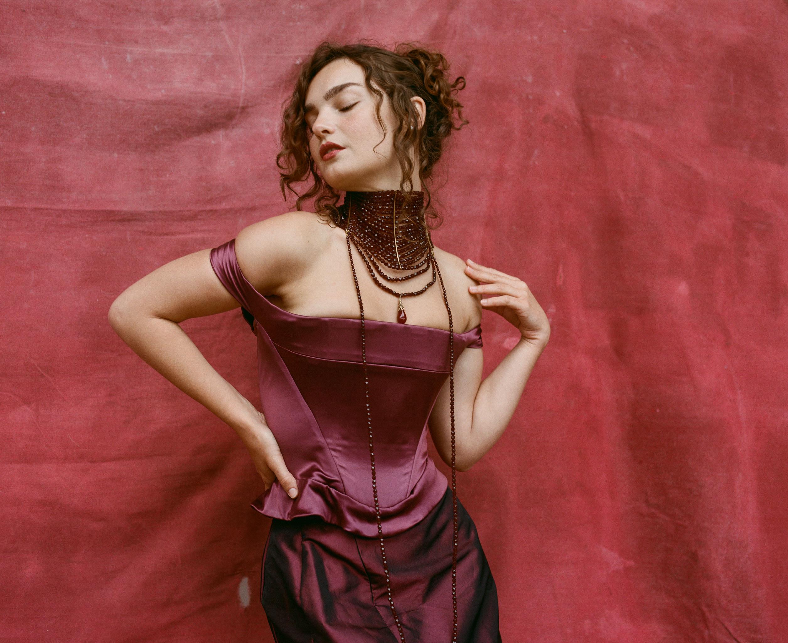 Vivienne Westwood corset and skirt ensemble from the Fall/Winter 1996 collection. The colour is an iridescent wine burgundy/dark purple in silk. 

Condition
Very good overall. The corset has no major flaws, some tarnishing to the zip. The exterior
