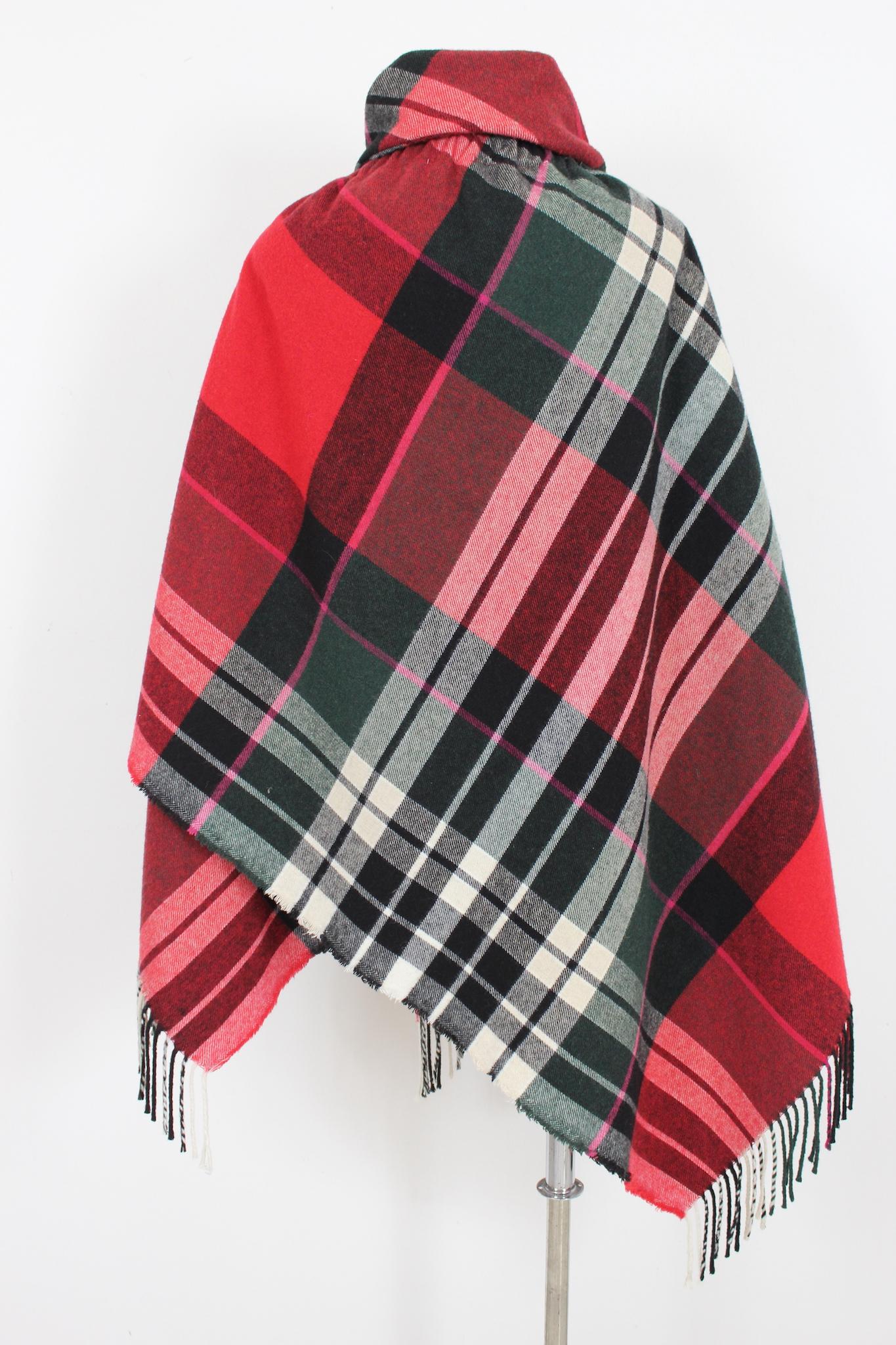 Wrap-around cape, red, green and black with tartan pattern by the designer Vivienne Westwood, 2000s. Soft shawl collar, closure with safety pin and fringes in the final part. Fabric in wool and other fibers. Made in Italy

Measures: 160 x 160