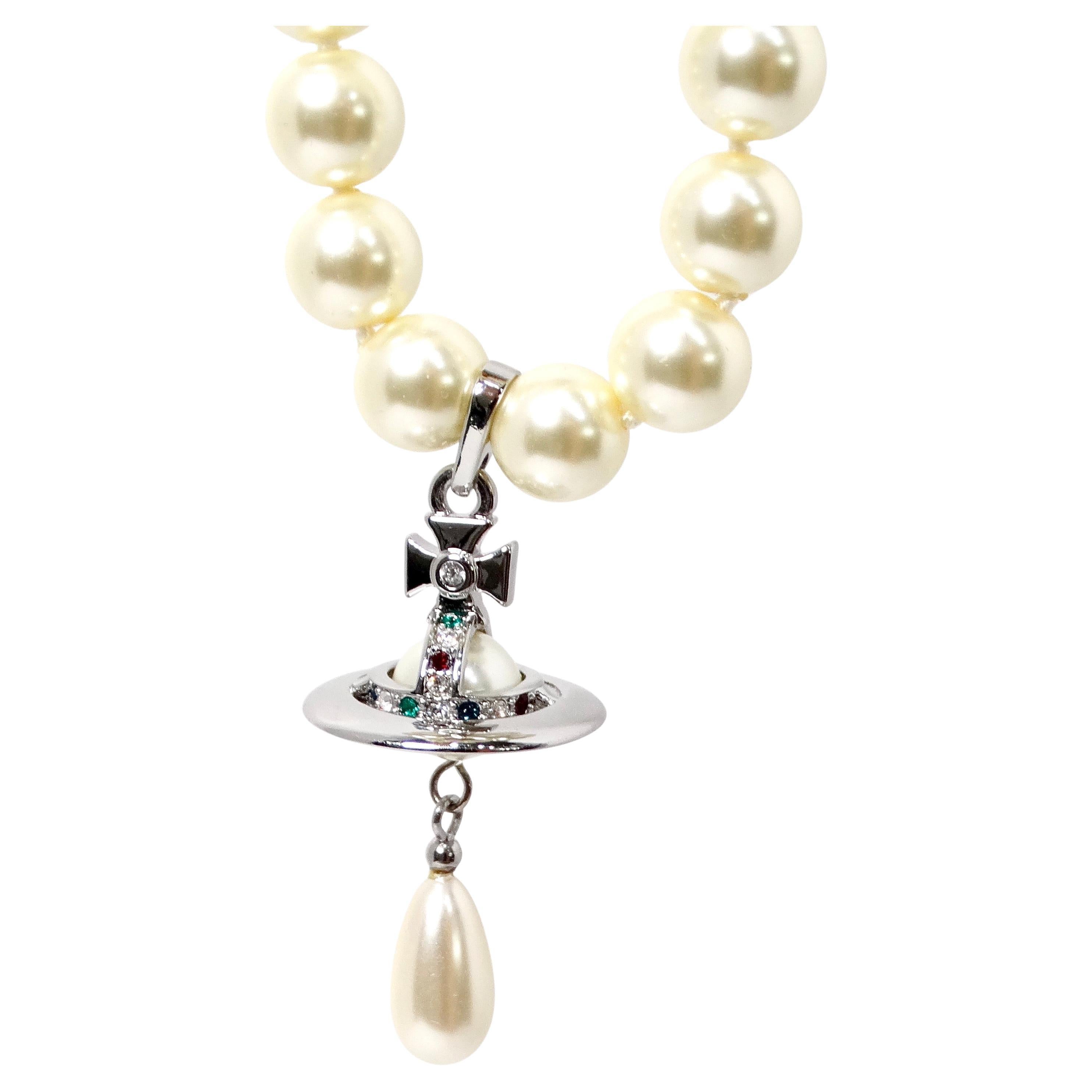 The Vivienne Westwood Three-Row Costume Pearl Orb Pendant Necklace is a striking statement piece that embodies the brand’s signature blend of punk-inspired elegance and modern sophistication. This luxurious necklace features three strands of