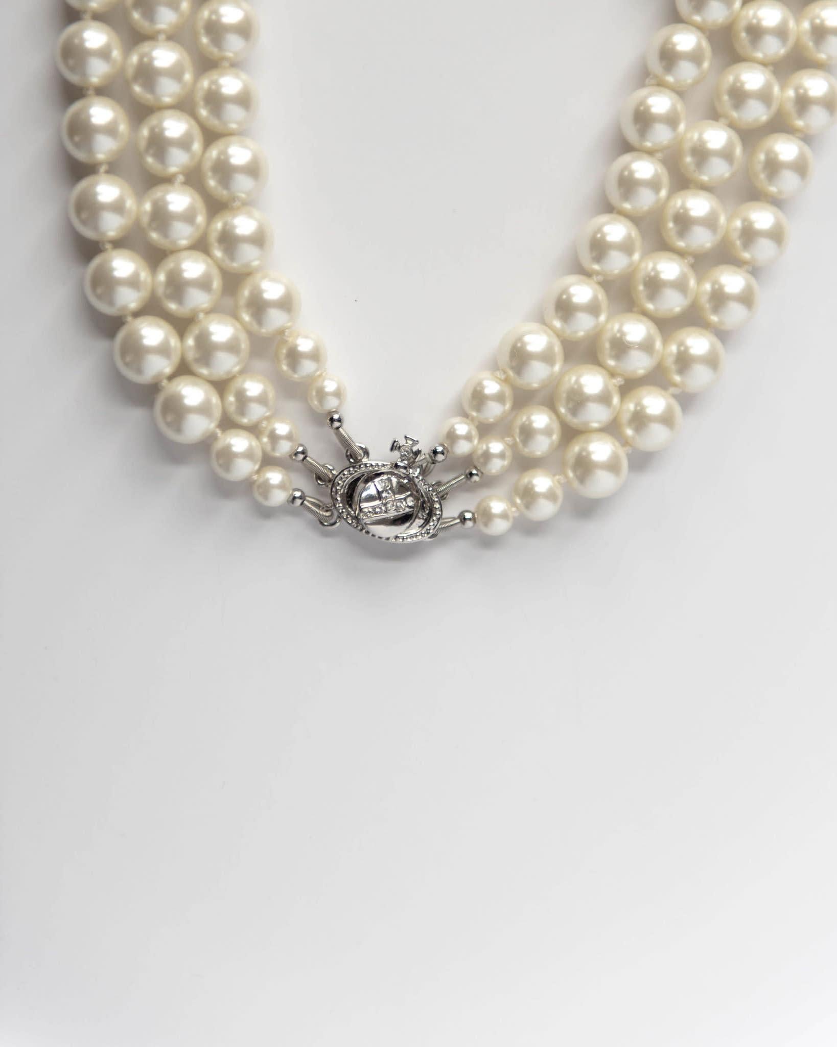 The iconic Vivienne Westwood pearl collection from decades ago is revisited. The sliver-tone three row pearl choker is hard knotted with rows of Swarovski pearls and set with the encrusted Orb at the centre. It’s deigned to hug the neck in true