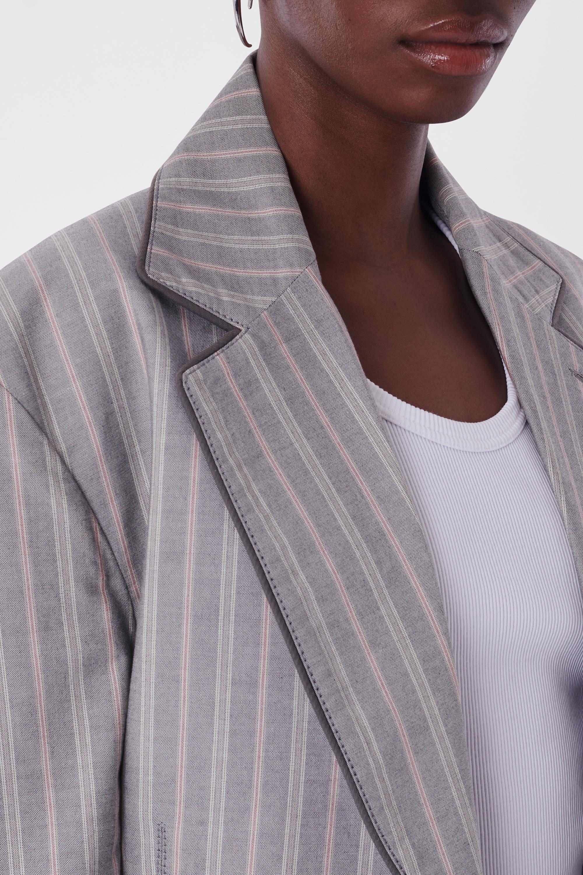 Vivienne Westwood Vintage S/S 1991 Pinstripe grey Suit. Features single breast, grey piping along lapel, 4 pockets on front, slim fit with zipper along the crotch on the trousers with button for closure. in excellent vintage condition.
Brand:
