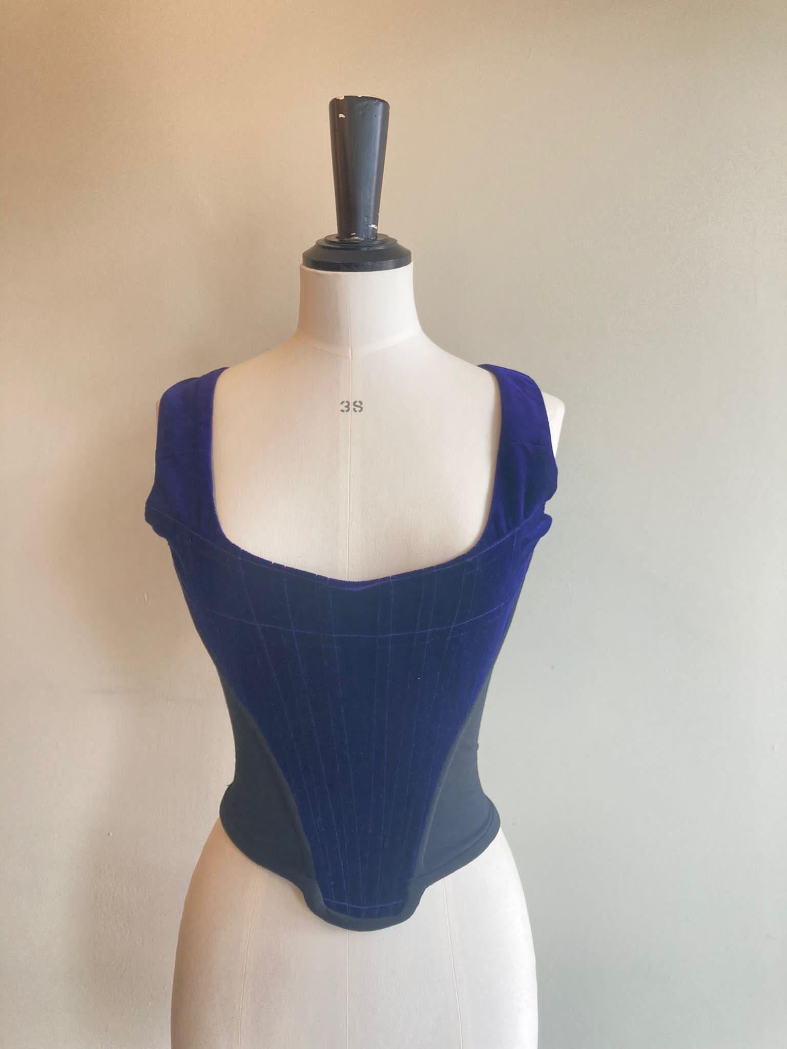 Vintage Vivienne Westwood velvet corset from the eponymous brand. Midnight blue cotton velvet with black cotton side panels. Structured front and back sections, with v-shaped structure at the front. Marked size UK 10. Fabric content: 100% cotton