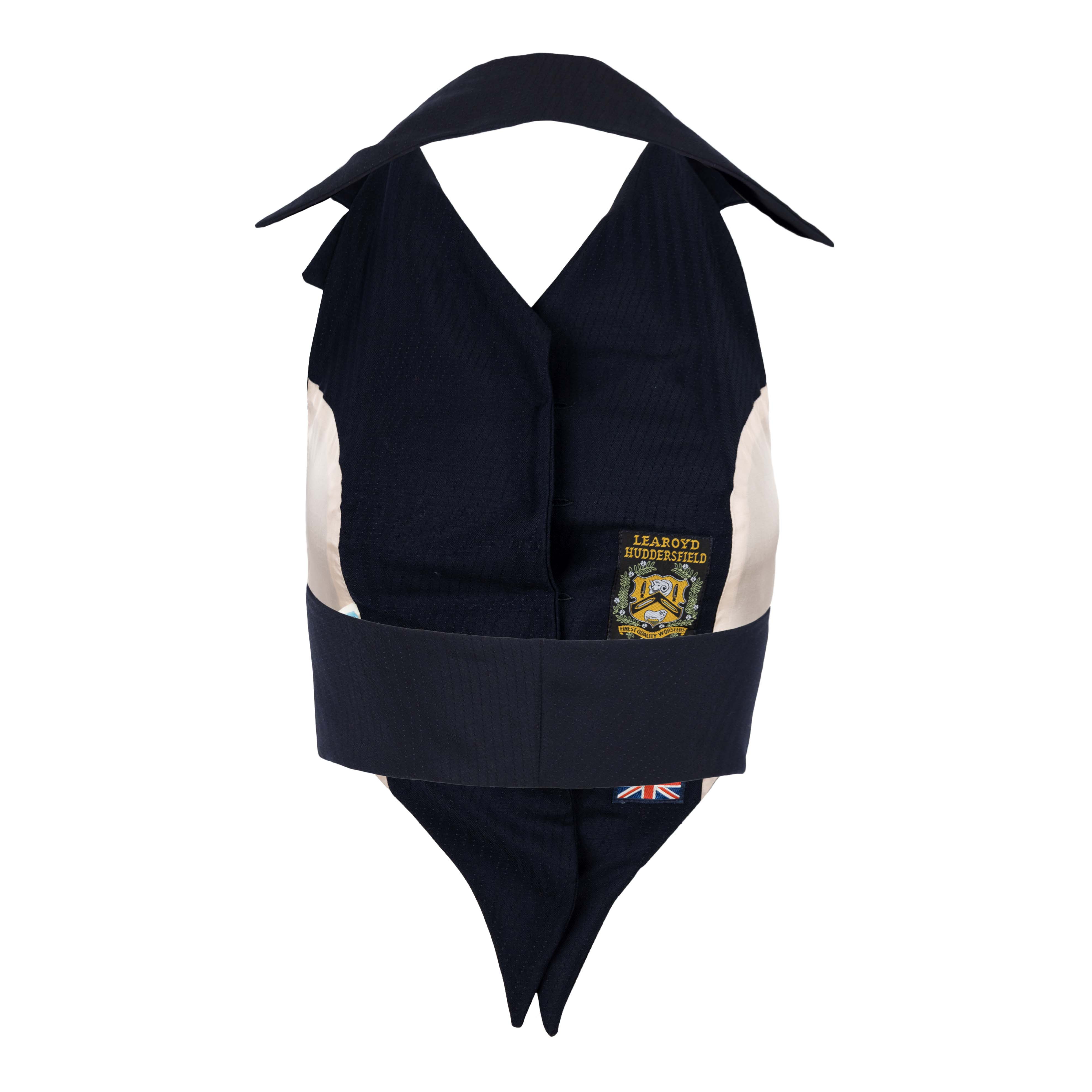The fitted waistcoat by Vivienne Westwood is a rare vintage piece which was made in England. The vest features gold tone logo buttons and a pointed tip. The elongated collar accentuates the silhouette of the waistcoat and makes it a perfect piece to