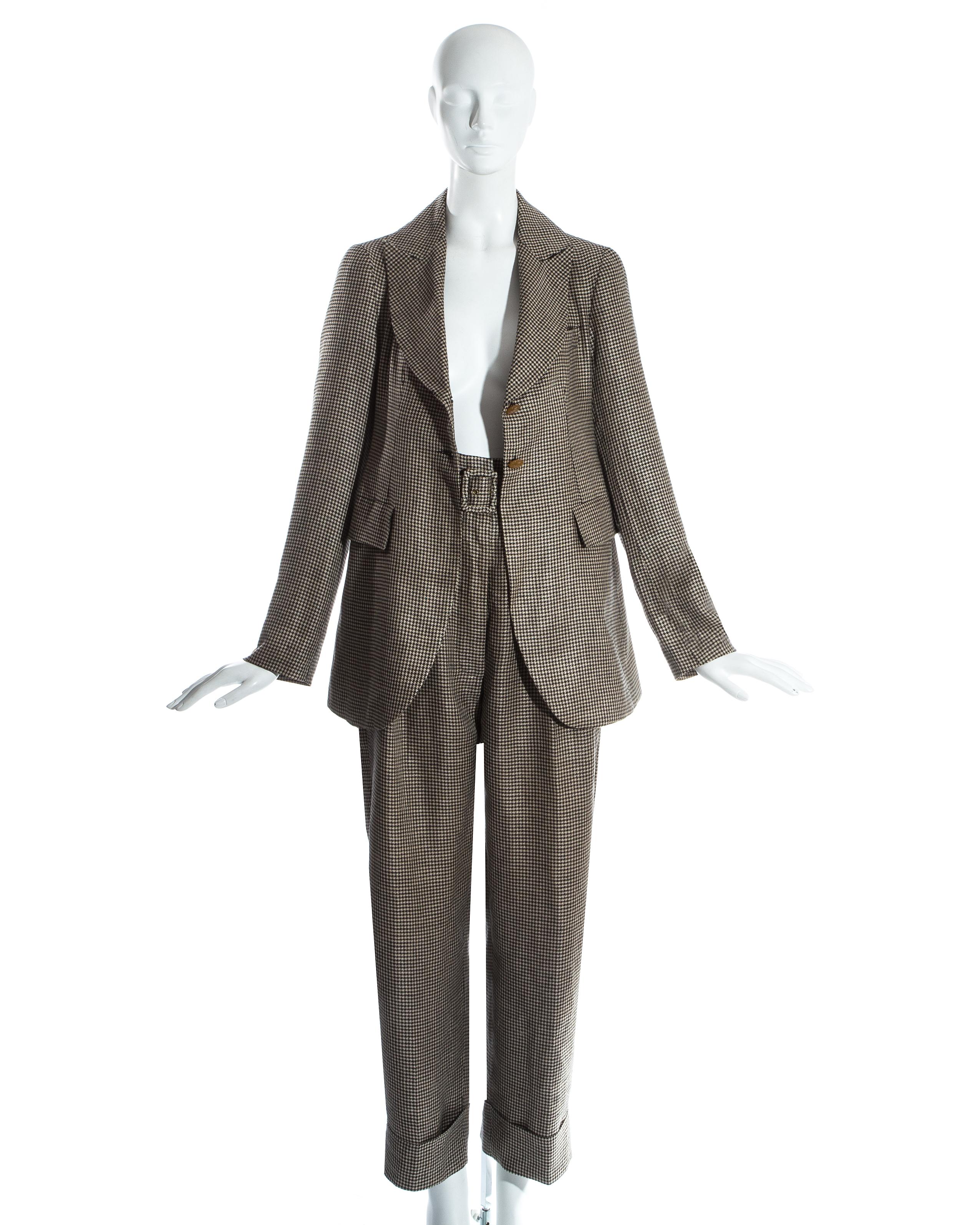 Vivienne Westwood black and white houndstooth wool pant suit. Blazer jacket with wide lapel and 2 button fastenings. High waisted turn up pants with matching fabric belt. 

Vive la Cocotte, Fall-Winter 1995