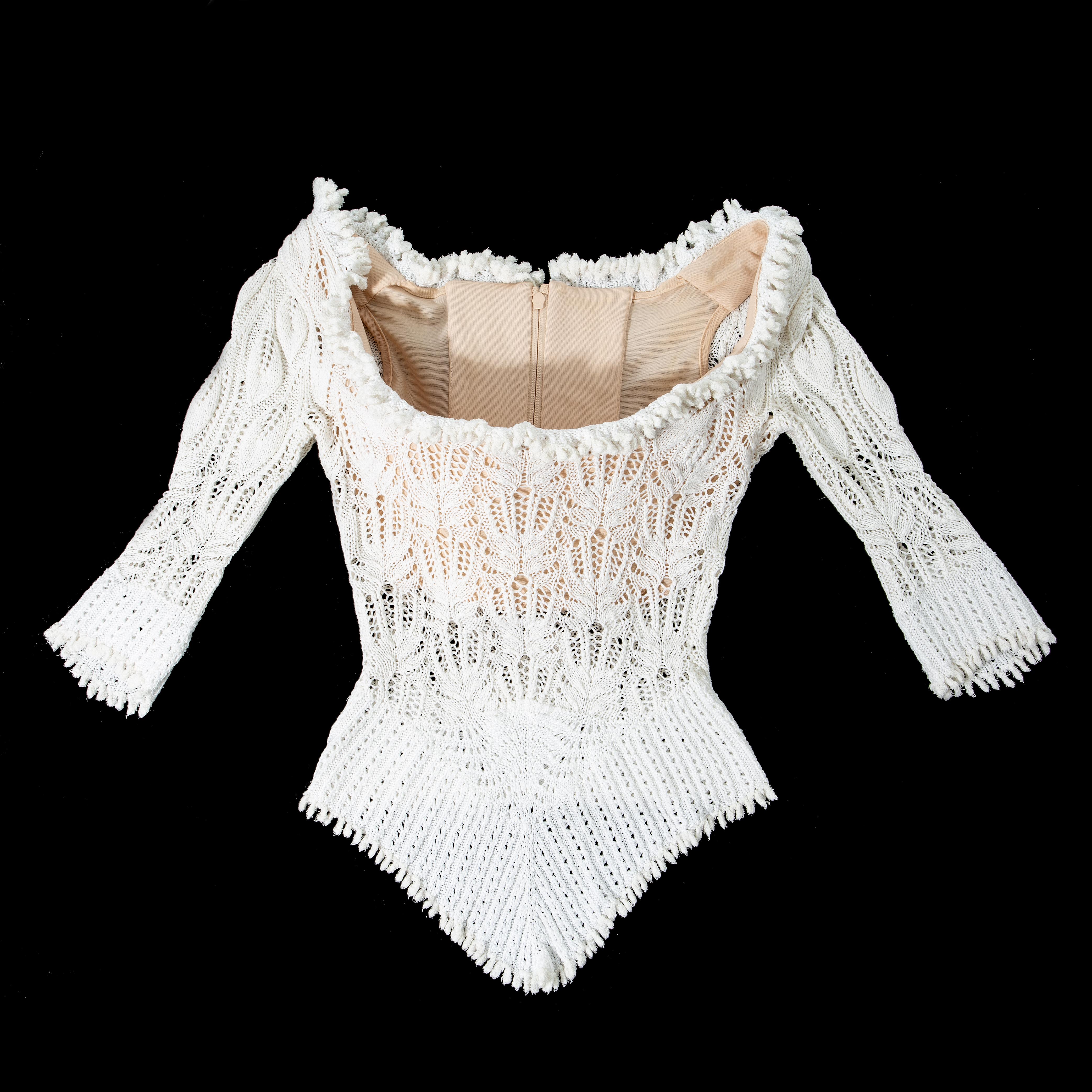 Vivienne Westwood white lace knit corset with wide neckline and fringed trim. Built in corset designed to cinch the waist and push the breasts up.

Spring-Summer 1994