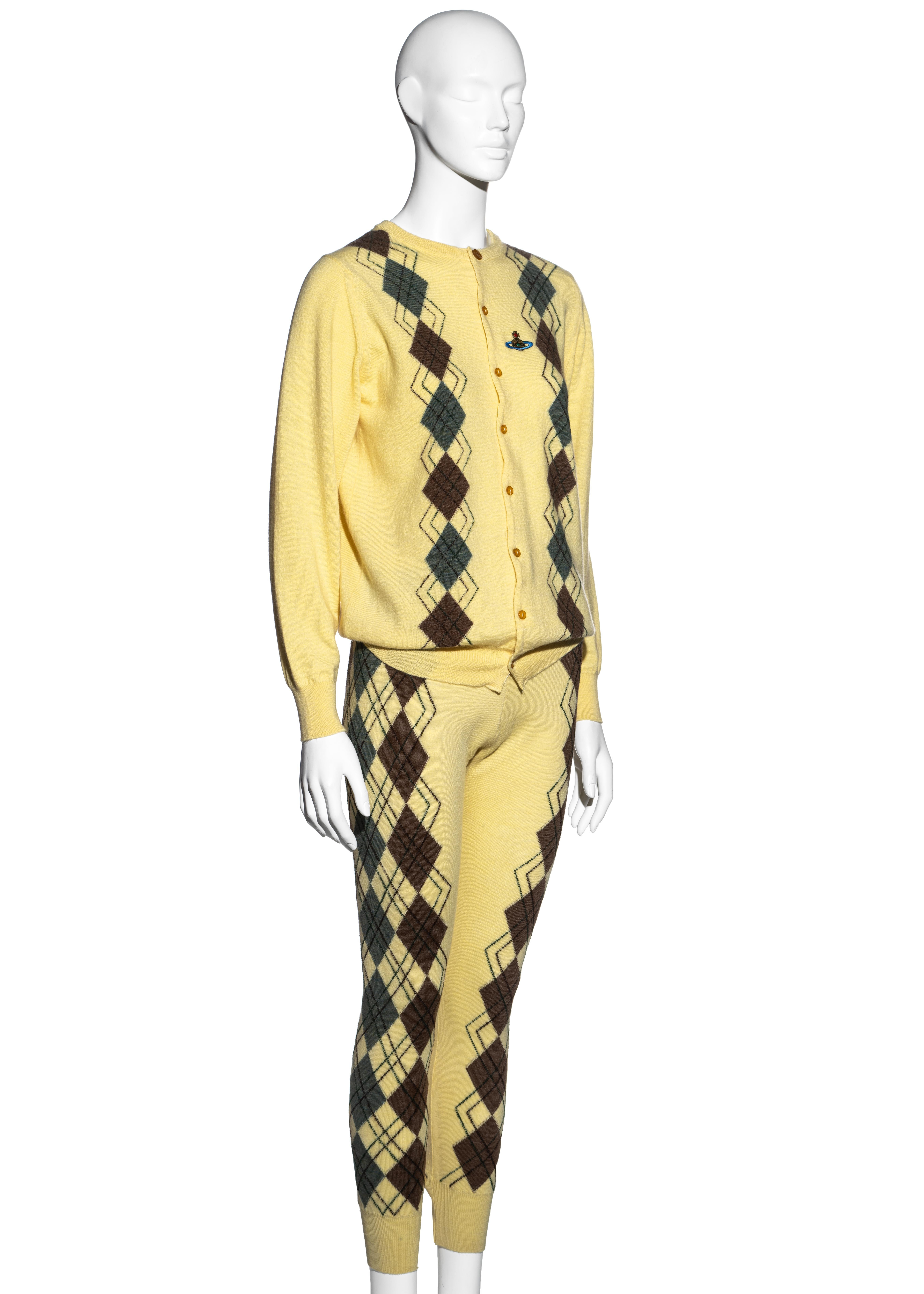 ▪ Vivienne Westwood yellow argyle knitted two piece set
▪ High waisted fitted leggings 
▪ Loose fitted cardigan 
▪ Embroidered orb on chest 
▪ Brown and green argyle pattern throughout 
▪ Size Medium
▪ Fall-Winter 1989