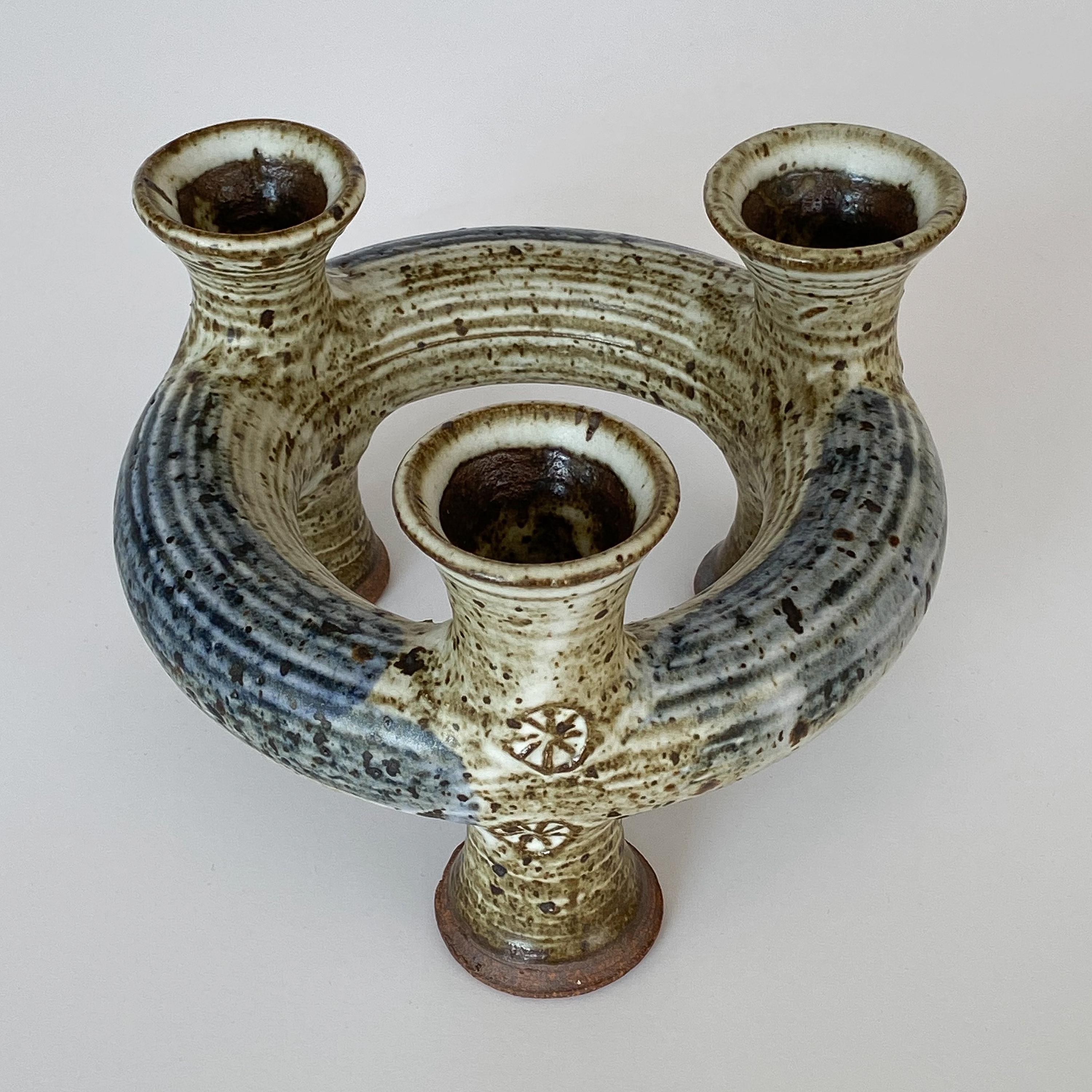 Unique and uncommon Studio Pottery candleholder by Vivika & Otto Heino, circa 1960s. Ring shaped form with trumpet shaped feet and candle cups. Holds three candles. Glazed stoneware pottery in blue, cream and light brown. Signed to underside of the