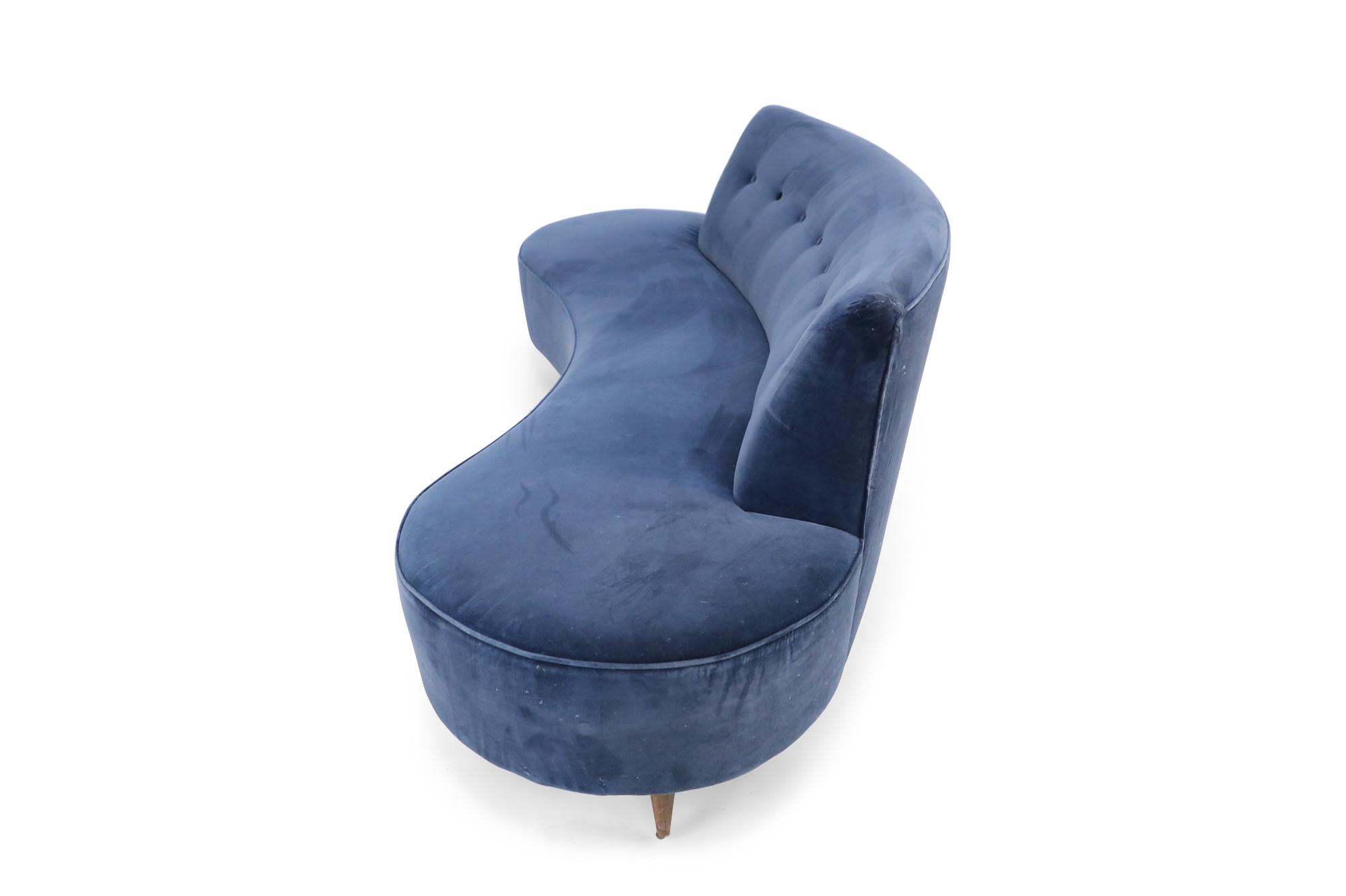 American mid-century style sofa with abstract shape, navy blue Colefax and Fowler velvet upholstery, and button tufted backrest in the style of Vladimir Kagan.
