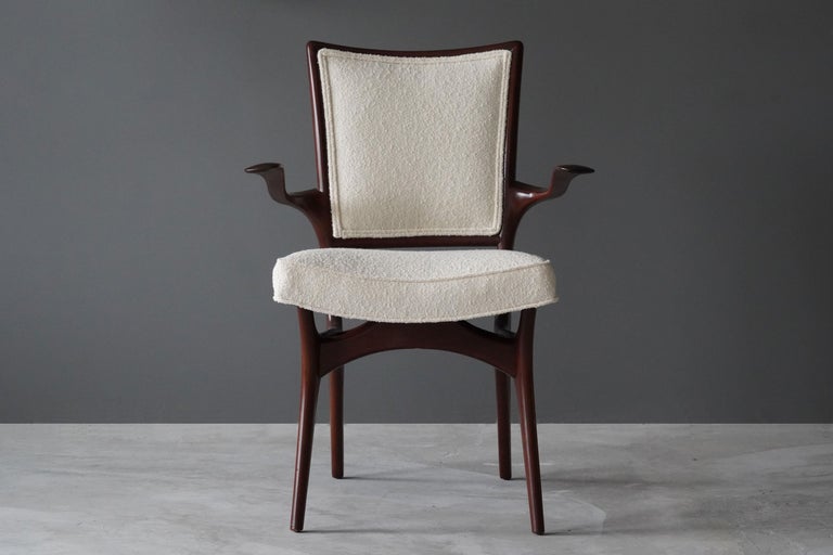 A sculptural organic armchair designed by Vladimir Kagan. Organicly carved walnut is paired with a high-end bouclé fabric.