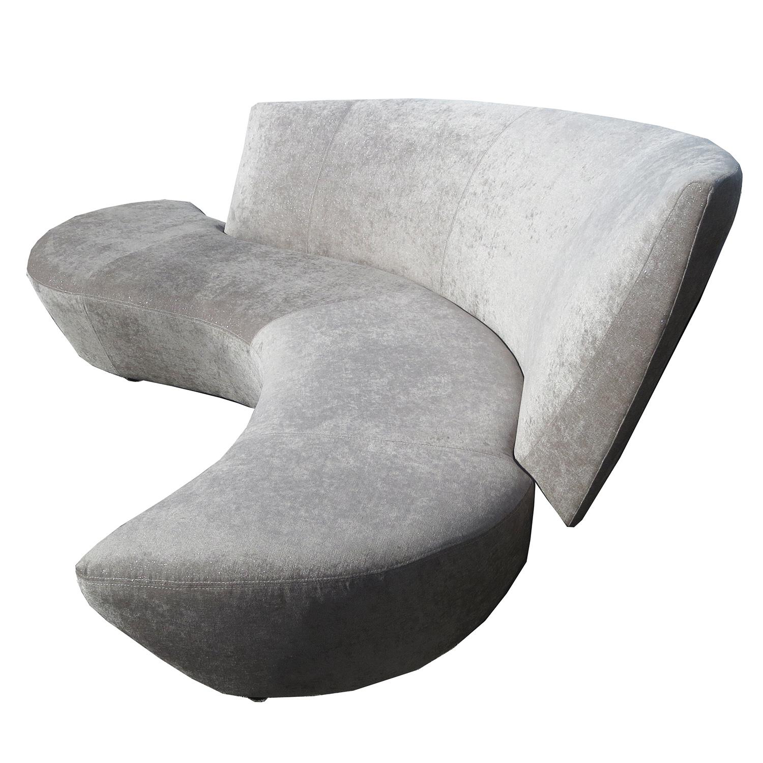 This undulating serpentine sofa was inspired by Frank Gehry's Bilbao Museum of Spain. Kagan combined angular and curved forms to create a unique design in seating luxury. We have re-upholstered the sofa in a taupe chenille fabric shot with silver