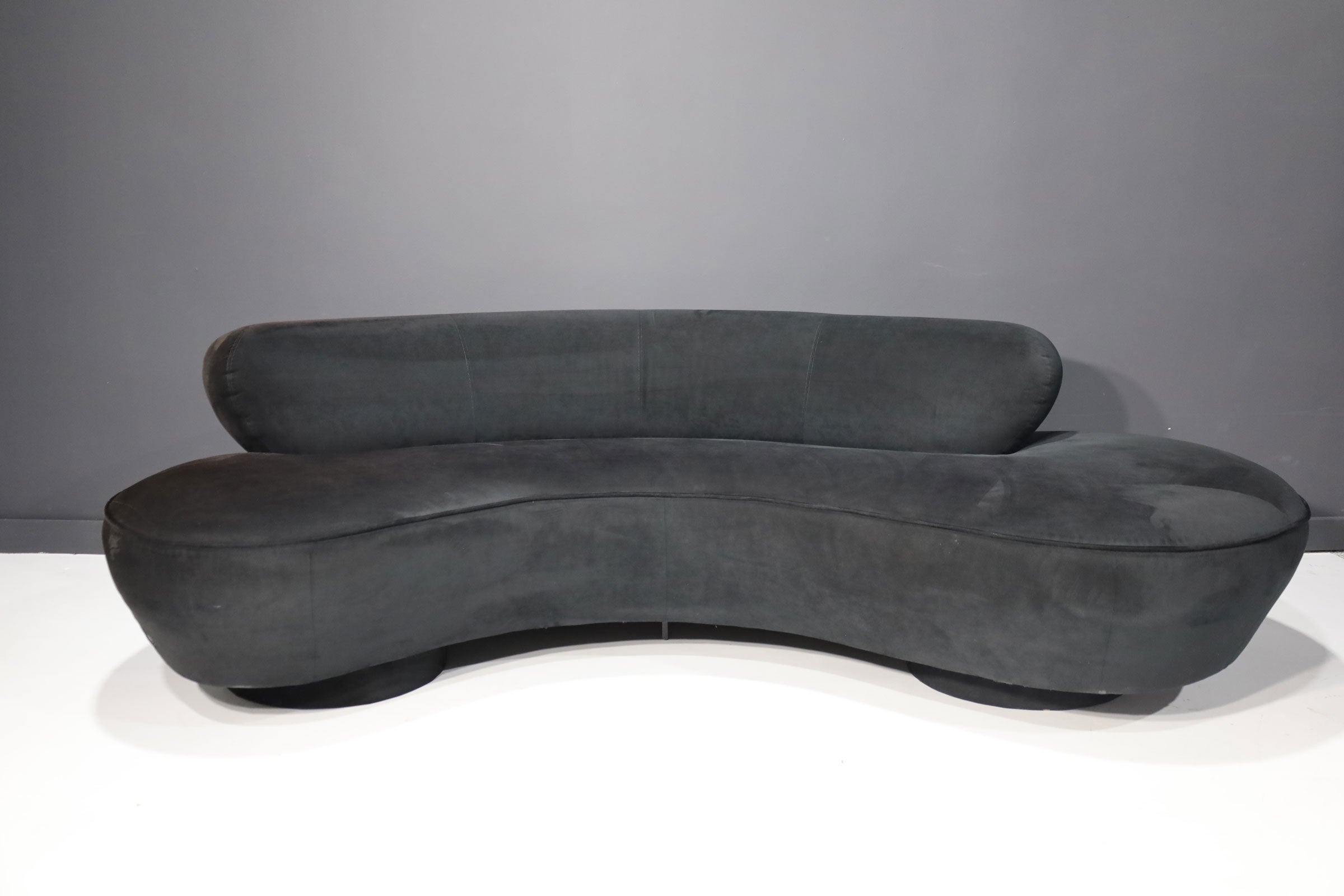 Vladimir Kagan's iconic cloud serpentine sofa by Directional. This sofa is upholstered in black microfiber. They would both need to be reupholstered to match. We recommend new upholstery on this one as well as fabric has some discoloration.