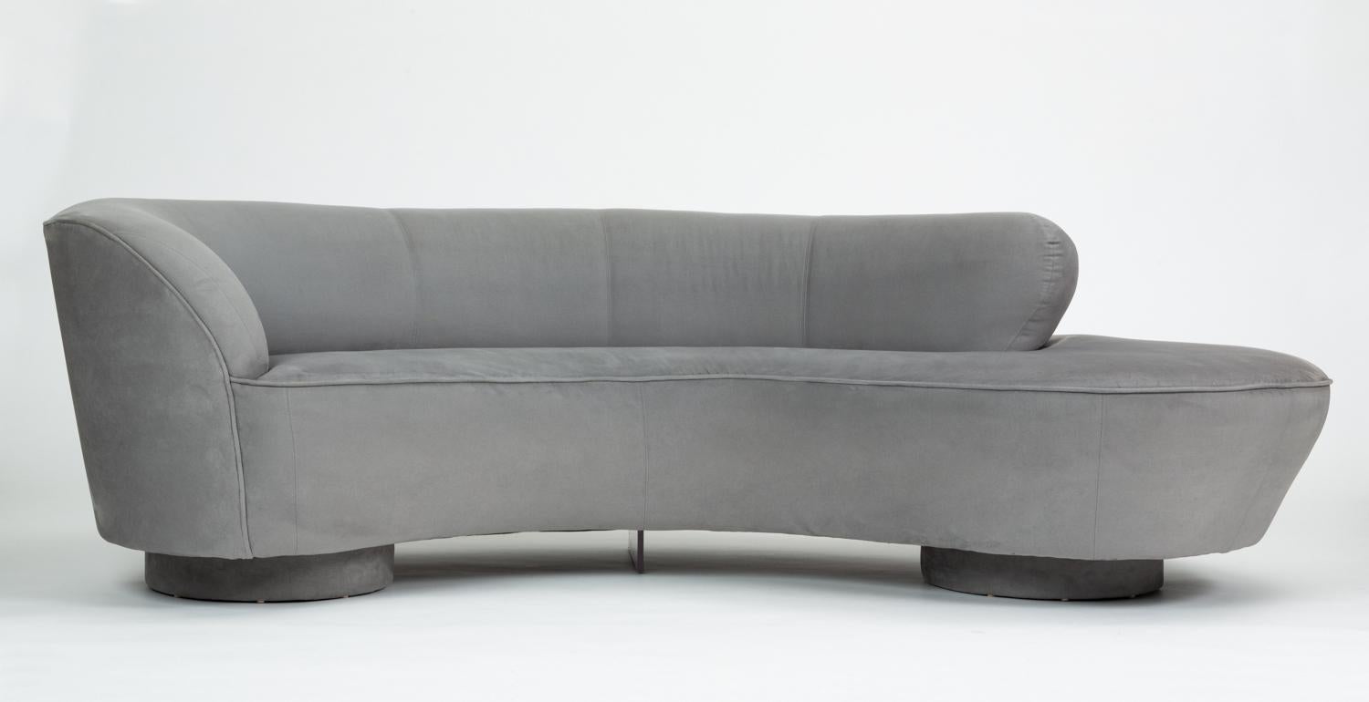 An outstanding example of Vladimir Kagan’s cloud sofa for Directional Furniture with matching ottoman. Both pieces are upholstered in the original gray microfiber, with topstitched seams segmenting the curved backrest. The asymmetrical seat wraps