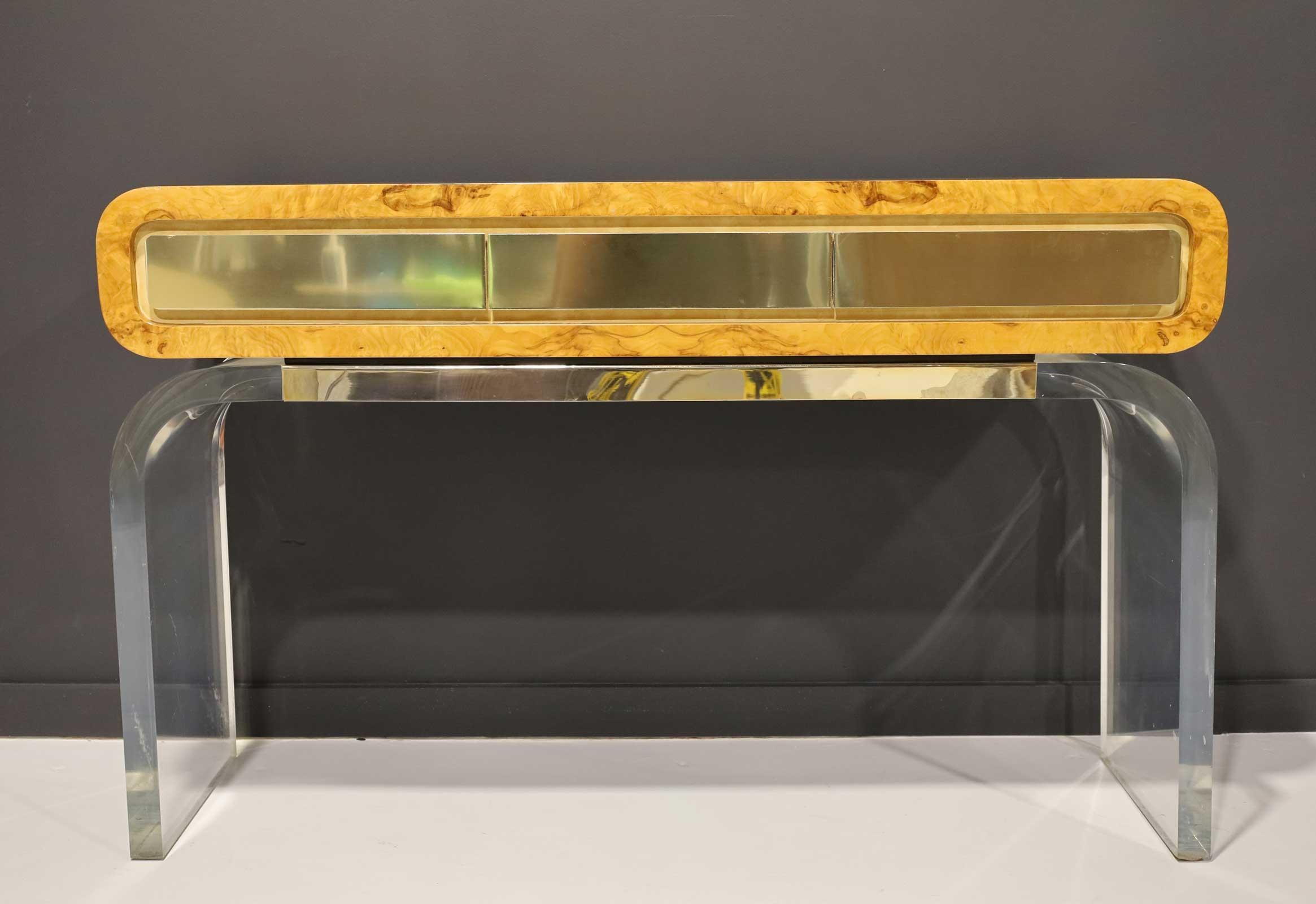 Very unique console designed by and manufactured by Vladimir Kagan. Console rests on a thick lucite base with curved sides. Console is bent burlwood with three drawers faced in brushed brass. Bears Kagan label inside drawer.