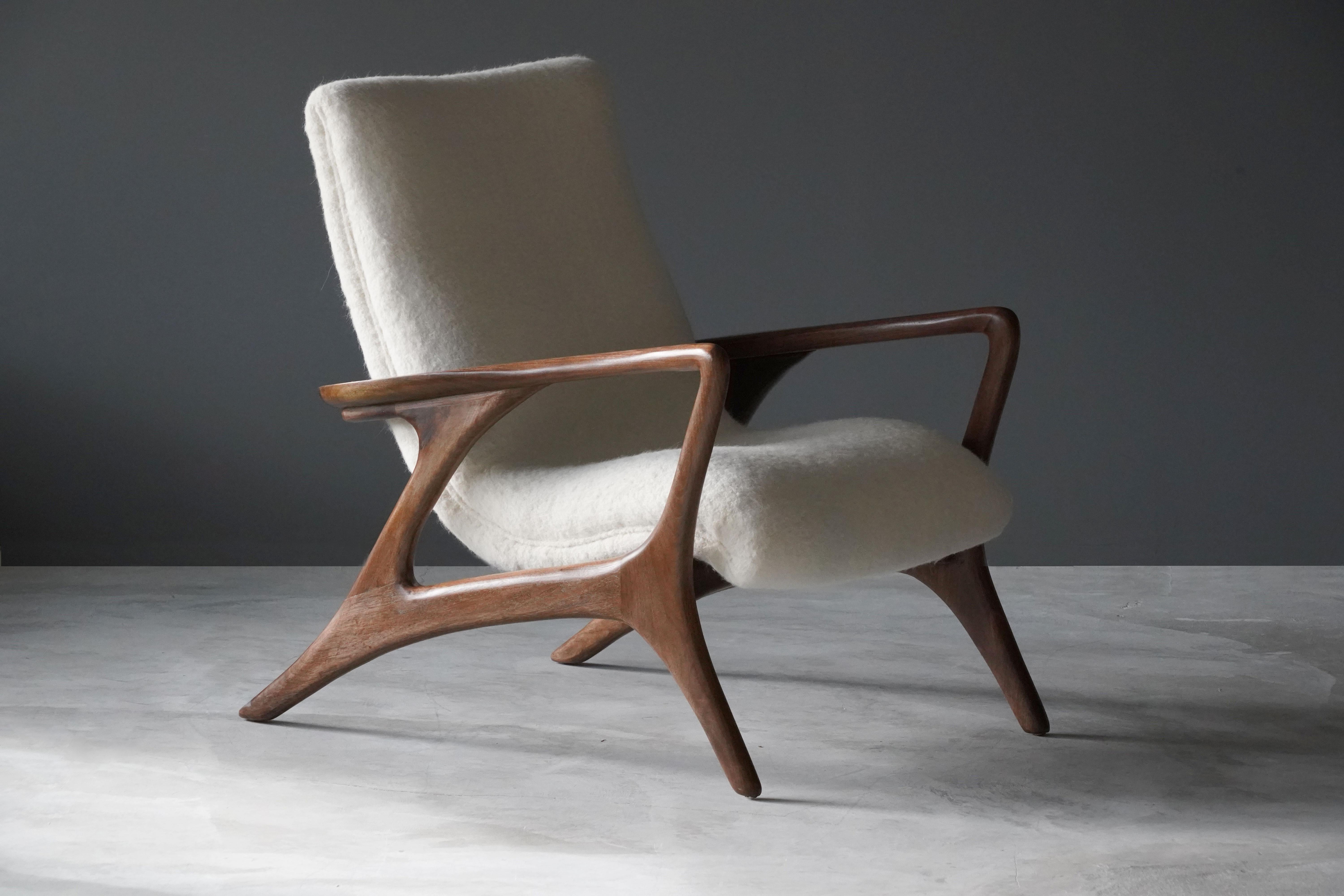 An organic lounge chair / arm chair by Vladimir Kagan. Sculpted walnut frame with overstuffed seat in white high-end European fabric. Bears label.

Designed in 1953, this example produced the last quarter of the 20th century. 


   