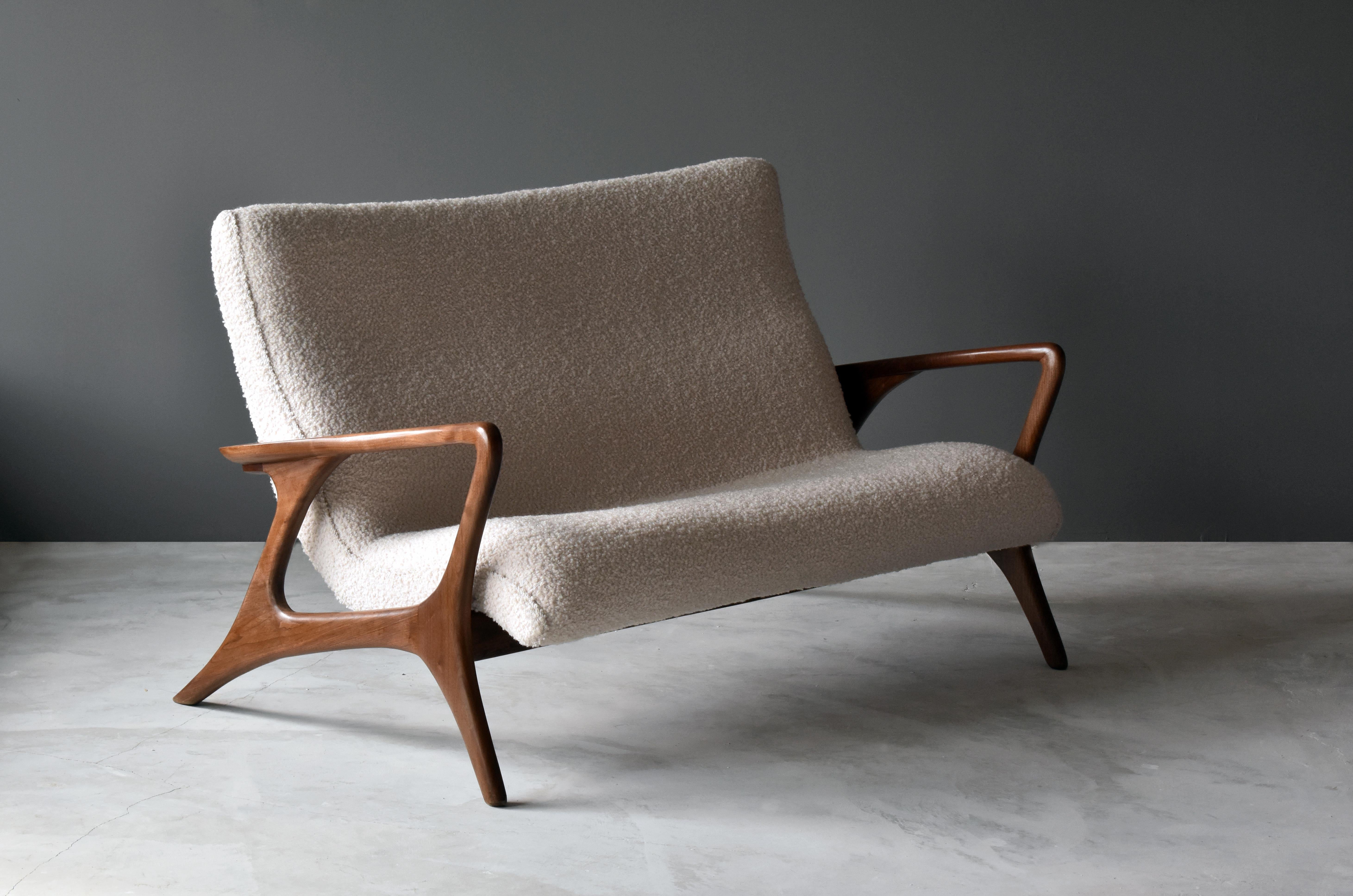 An organic sofa, settee or love seat by Vladimir Kagan. Sculpted walnut frame with overstuffed seat in white high-end European Bouclé. Bears label.

Present example is an early one produced in the studio of Vladimir Kagan in the 1970s. 

Other