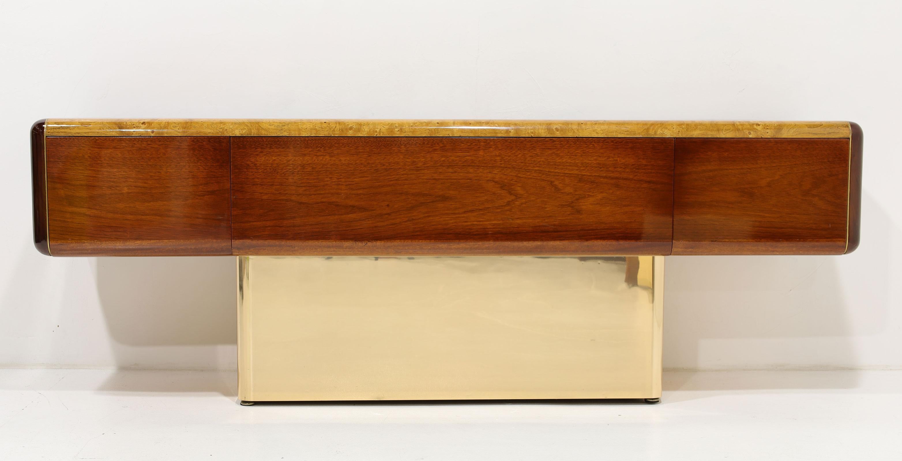 Stunning handcrafted desk by Vladimir Kagan. Desk features a burl wood top and mahogany surround, both highly polished. Base is wood with a brass finish metal overlay. There is a brass inlay between mahogany and burl. The desk features three