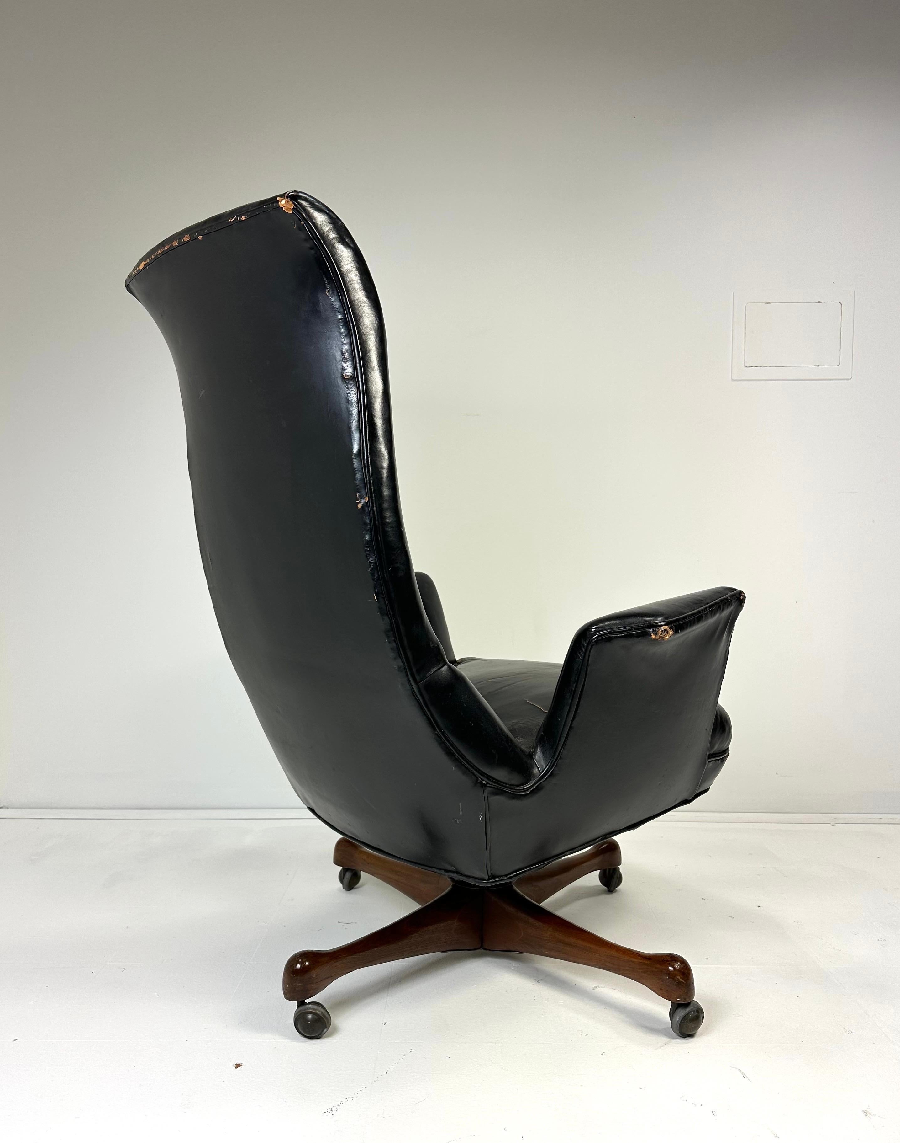 Vladimir Kagan high back executive chair. Sculpted walnut swivel base with casters. Original black leather. upholstery. Kagan-Dreyfuss. 1960’s. Unmarked
