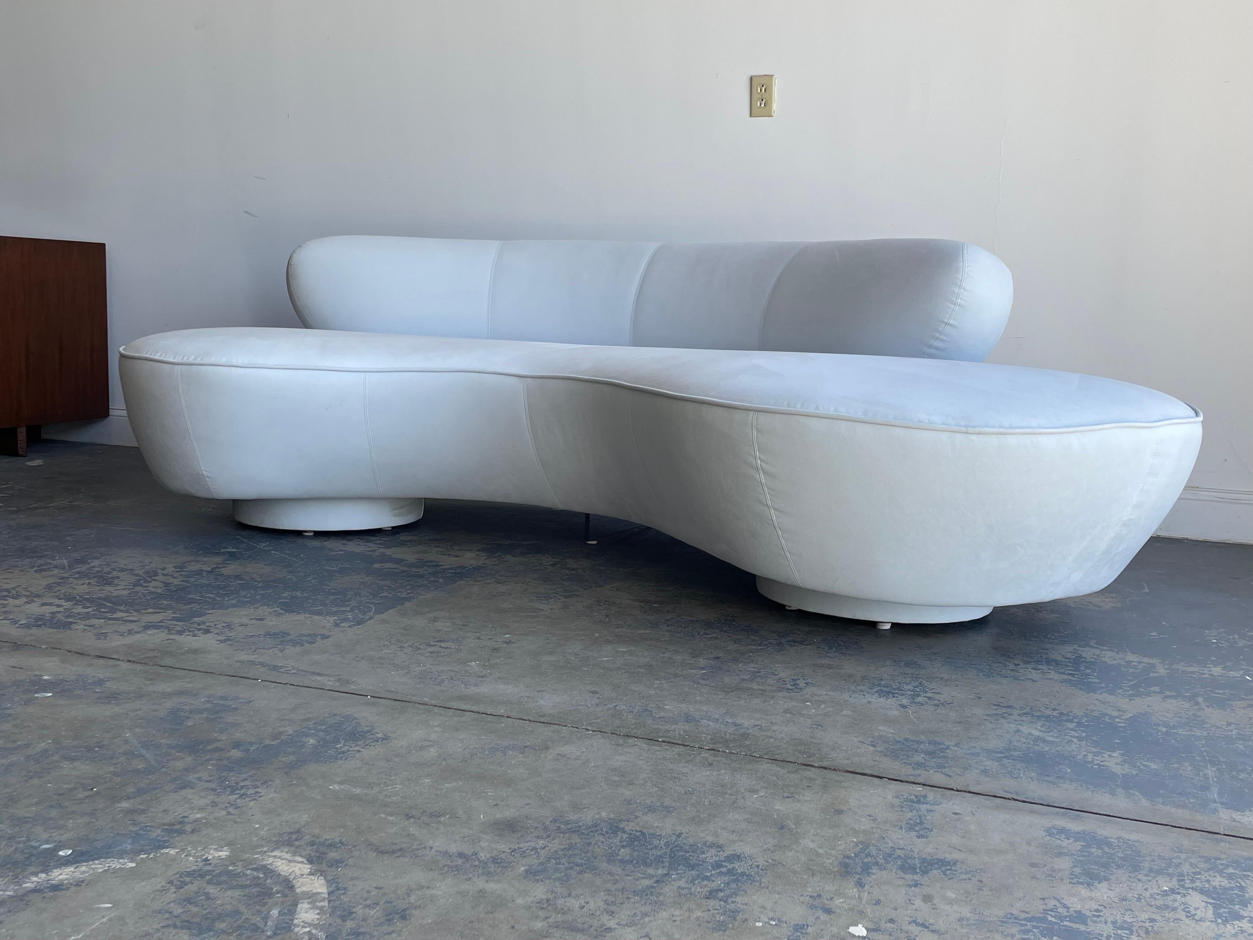 A classic sofa designed by Vladimir Kagan for Directional. Features a very light off white with blue hue microsuede upholstery, above two round pedestal bases and a lucite center support. Great organic design in an uncommon color. 

Sofa was