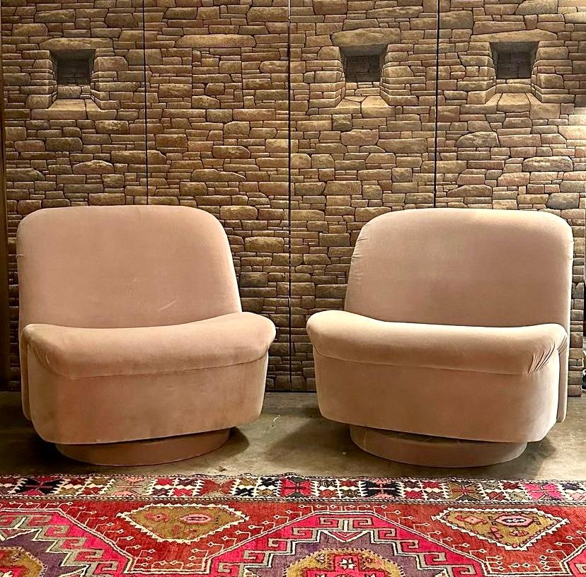 Pair of Vladimir Kagan for Directional swivel and tilt lounge chairs, circa 1980s. This vintage sculptural chair  has a slightly curved back and seat which tilts and swivels on an upholstered round base. Postmodern lounge chairs are upholstered in