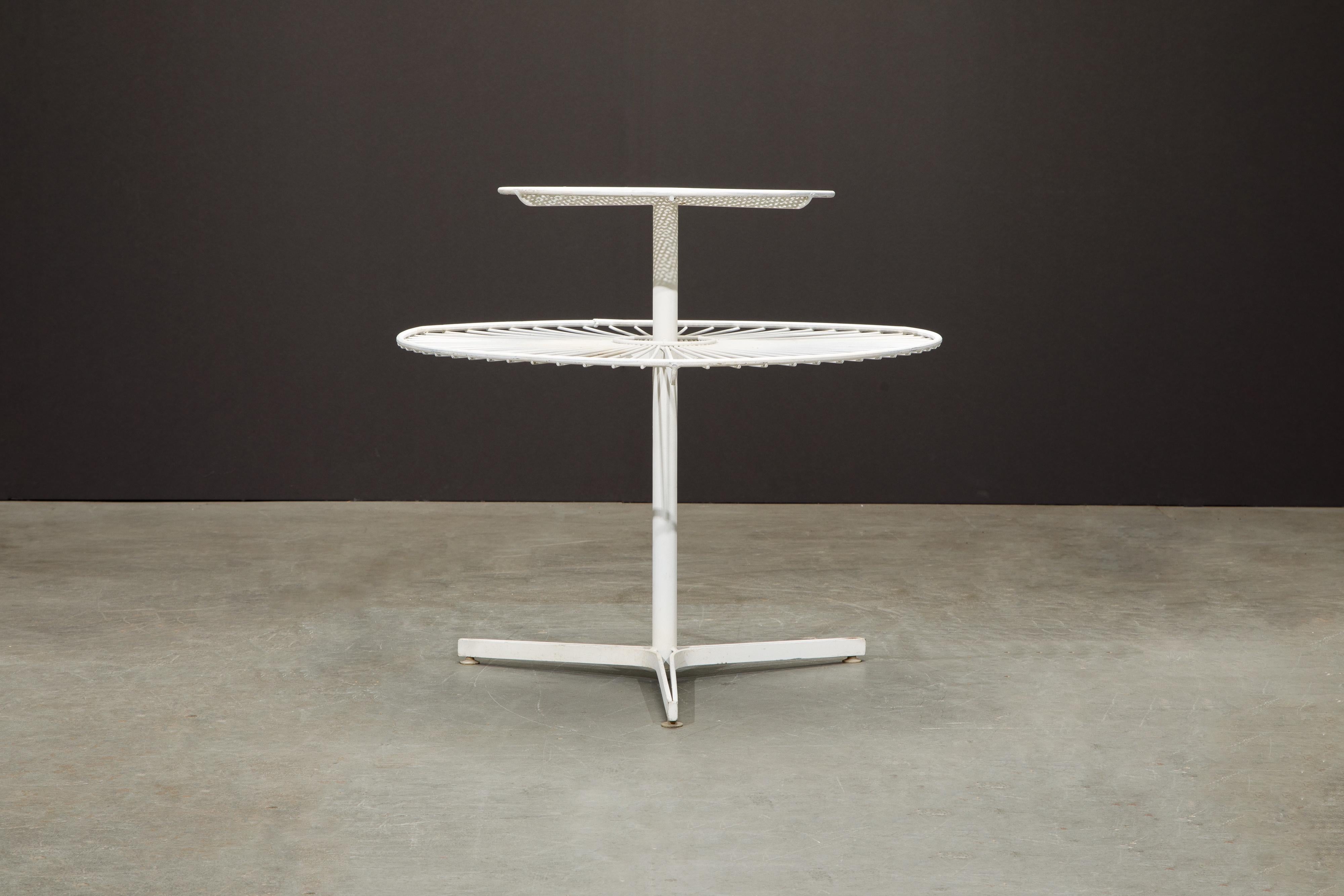 This rare collectors piece is an early Vladimir Kagan for Kagan-Dreyfuss 'Capricorn' tiered side table featuring a pierced enameled steel top which is reminiscent of designs by Mathieu Matégot and then the lower tier is in Kagan's signature spaced