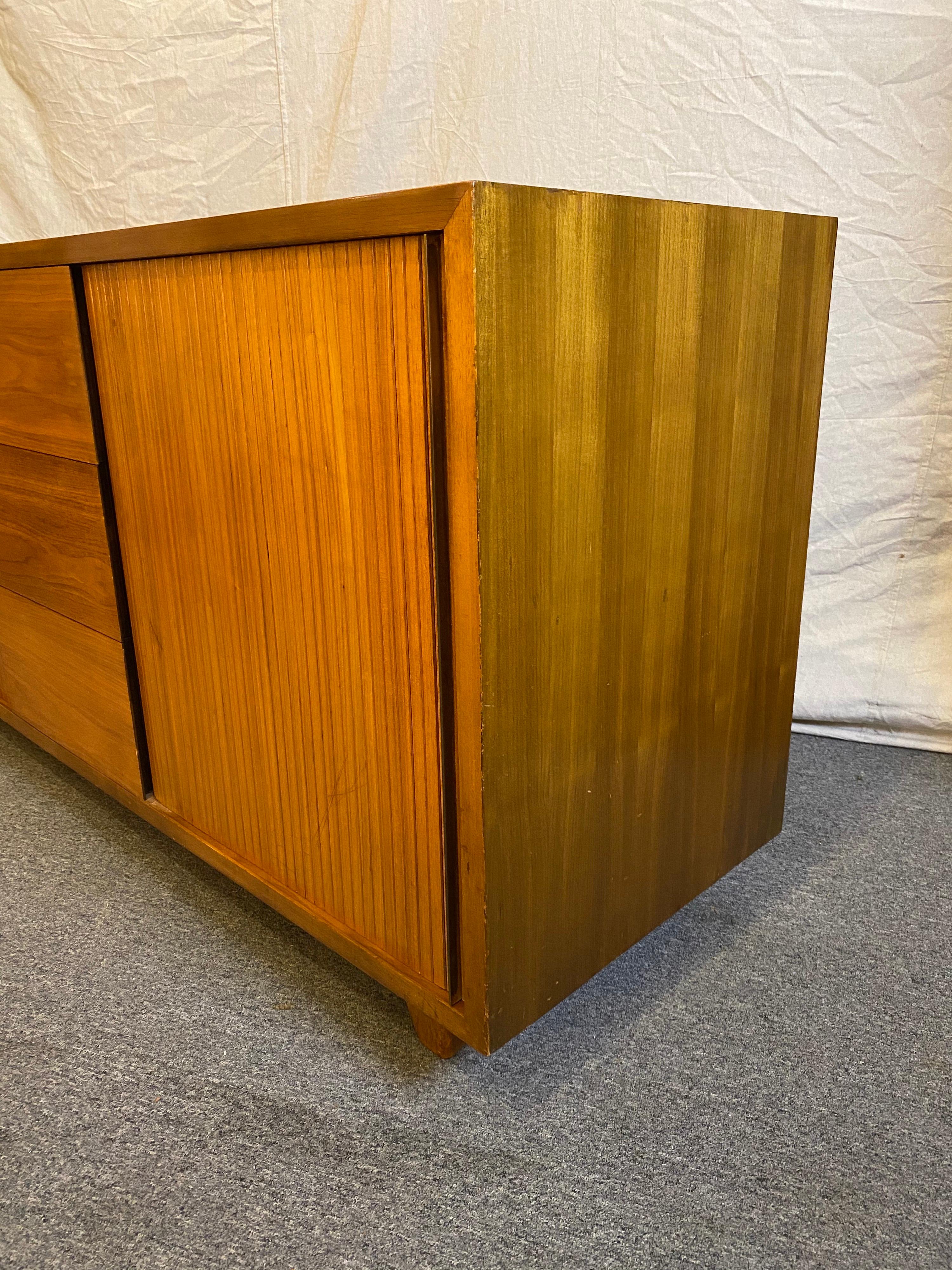 Vladimir Kagan for Kagan/ Dreyfuss walnut credenza or bedroom cabinet. Tambour doors with brass handles at each end slide open to reveal pullout or pull-out drawers. 3 center drawers allow for plenty of storage! Splayed legs support the cabinet.