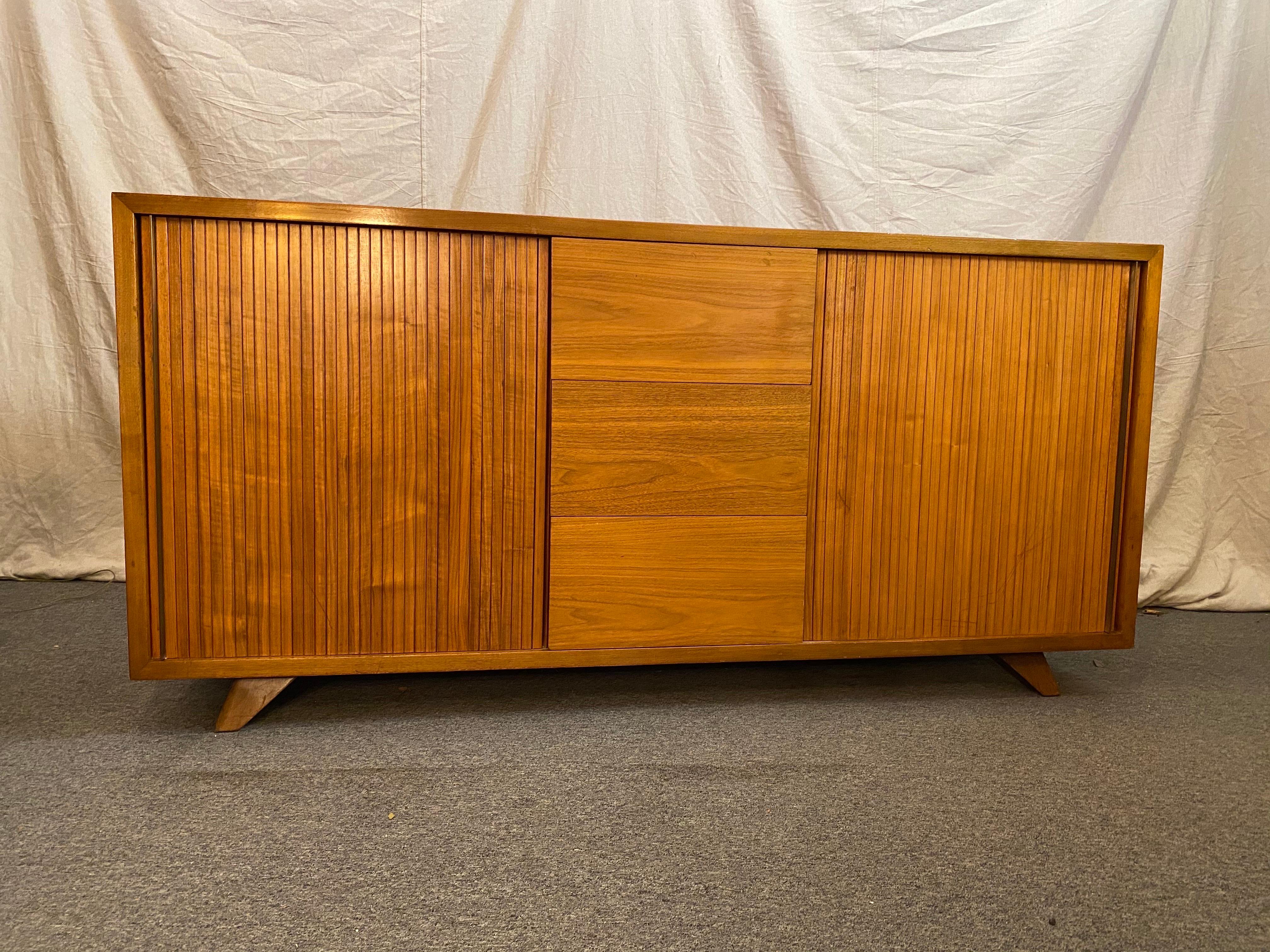 Vladimir Kagan for Kagan/ Dreyfuss walnut credenza or bedroom cabinet. Tambour doors with brass handles at each end slide open to reveal pull-out drawers. 3 center drawers allow for plenty of storage! Splayed legs support the cabinet. Original