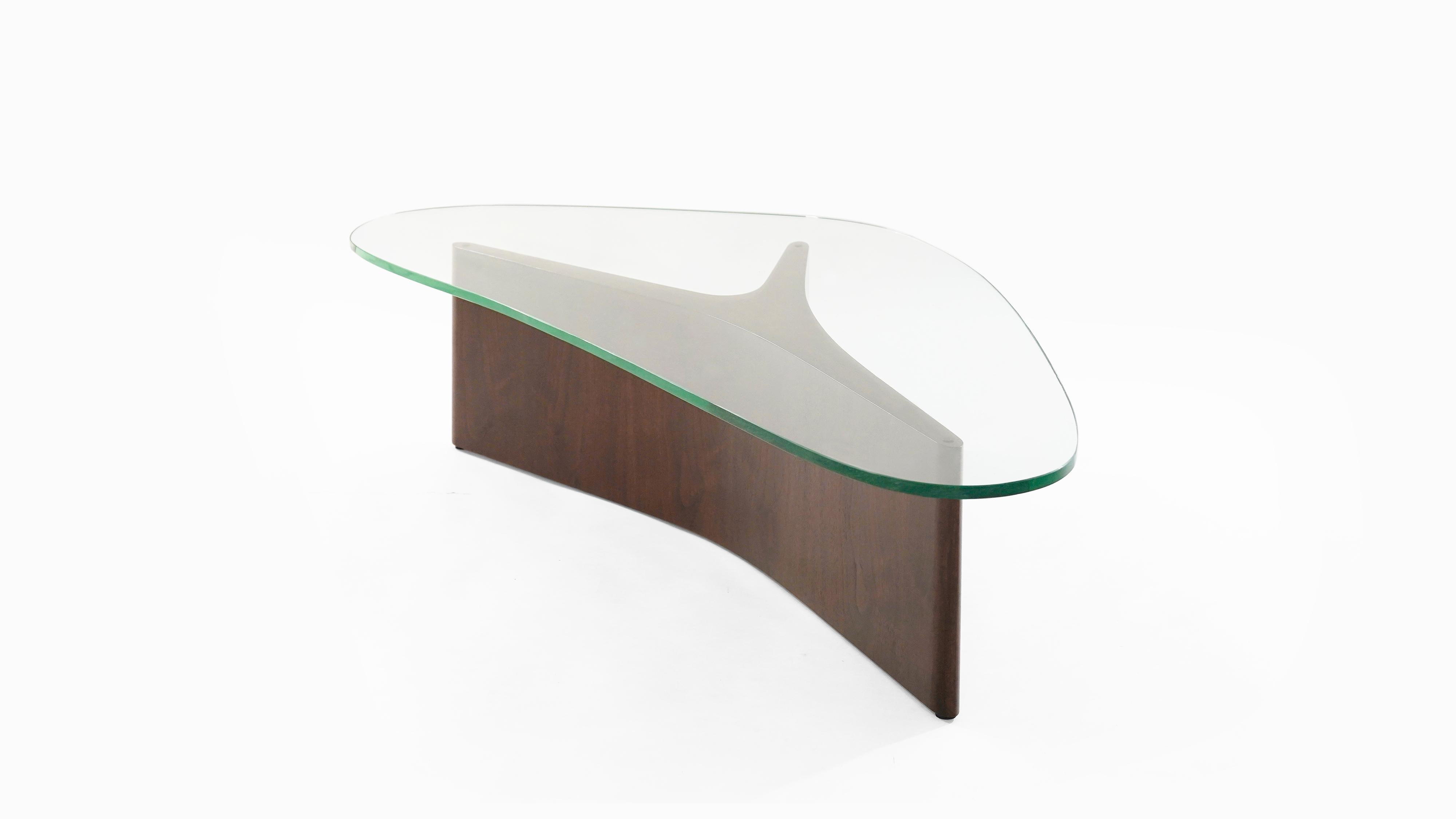 Sculptural coffee table executed in walnut. An early designed by Vladimir Kagan for Kagan-Dreyfuss, Inc., circa 1950s. Walnut fully restored, new glass top matching the shape of the original. Stamped underneath.