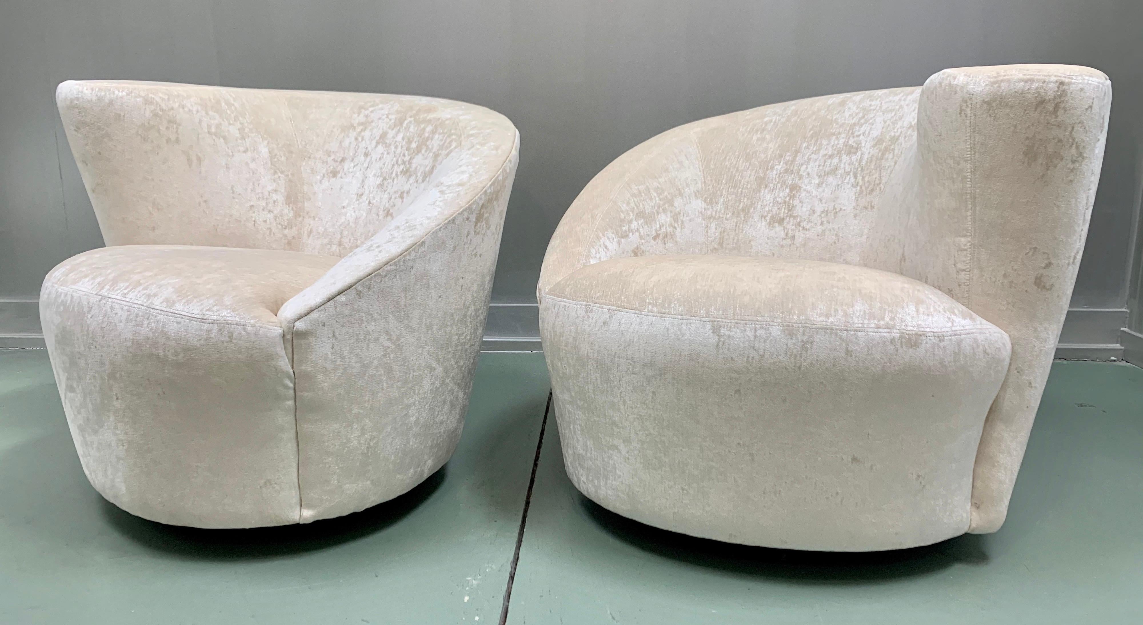 Magnificent pair of newly upholstered Kagan Nautilus swivel chairs. The fabric is an off white or cream velvet that is gorgeous. The ultimate in comfort and design and one of the true iconic midcentury pieces today.